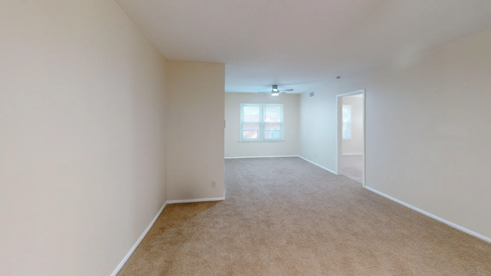 Neutral tone wall paint, carpeted flooring, multiple windows, and a ceiling fan