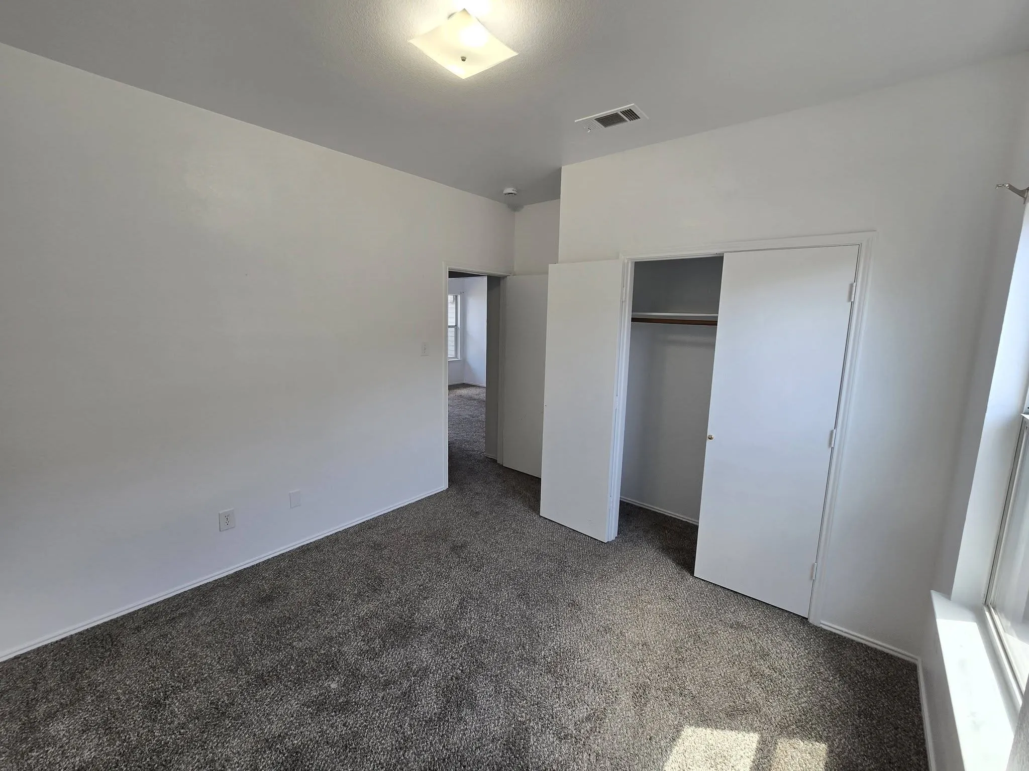 Plush gray carpeting, white walls, and a recessed ceiling light fixture