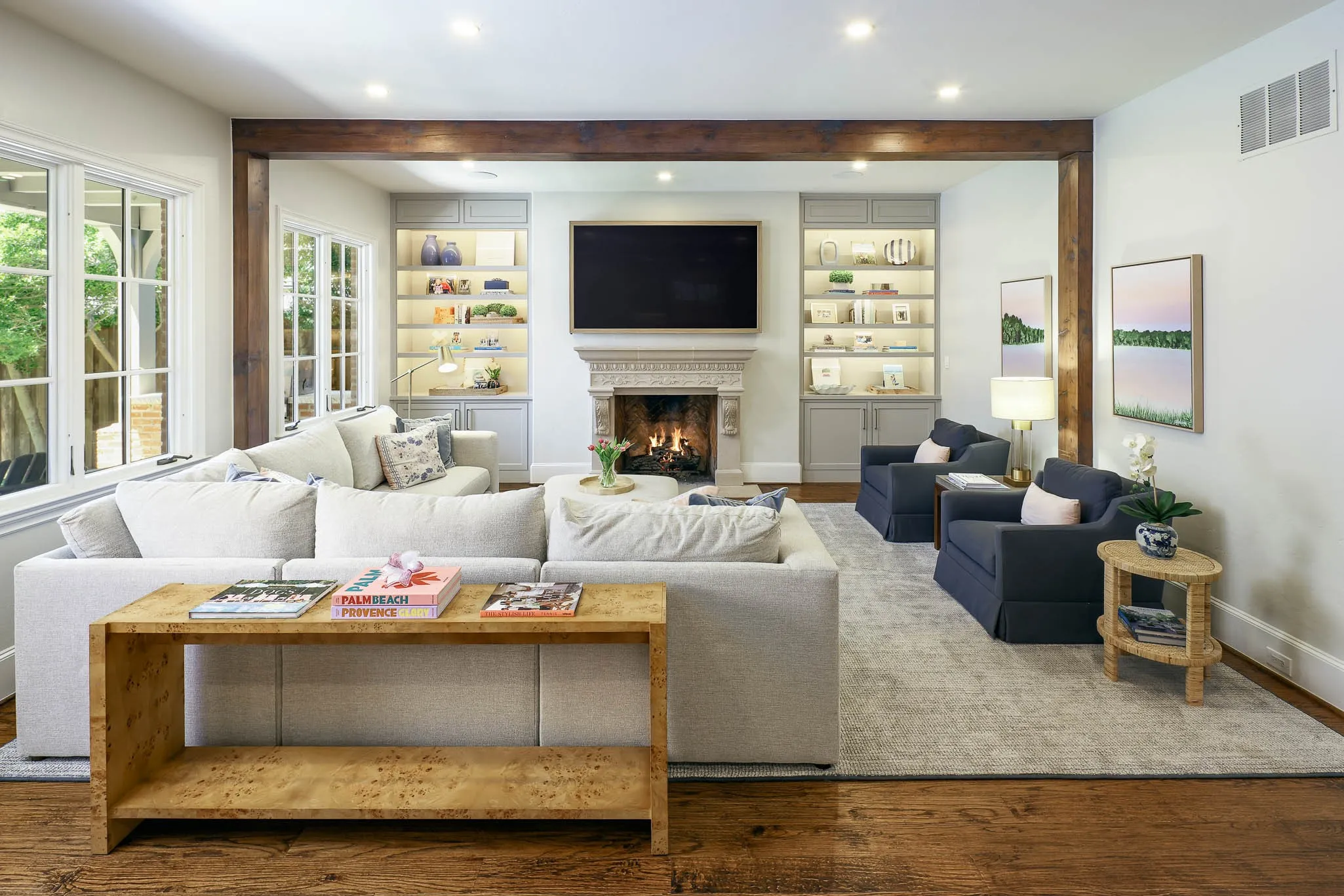 Living room with lgas fireplace, wood beamed ceiling, and built-in cabinetry and shelving