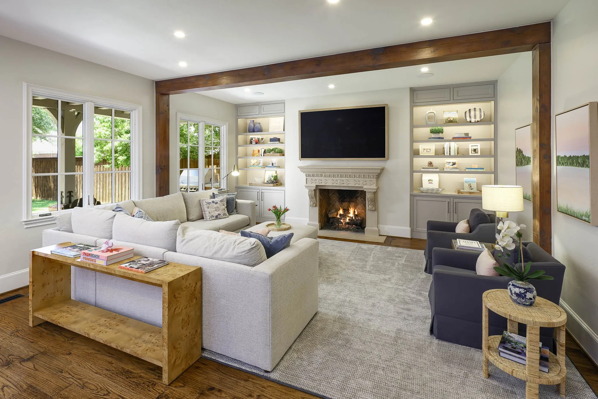 Living room with gas fireplace, wood beamed ceiling, and built-in cabinetry and custom built ins