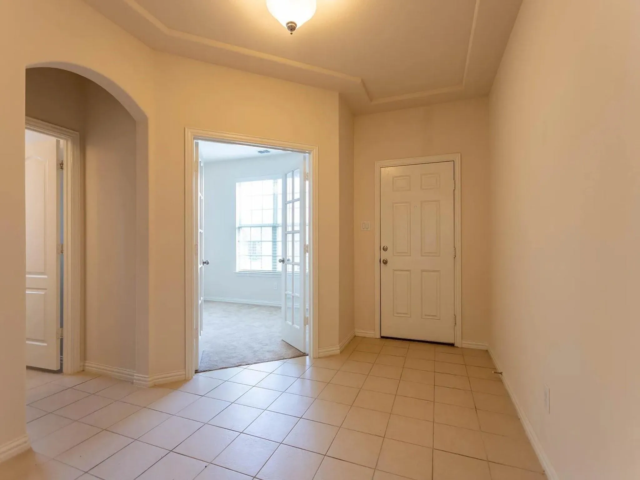 Tile flooring entryway with tray ceiling and recessed lighting