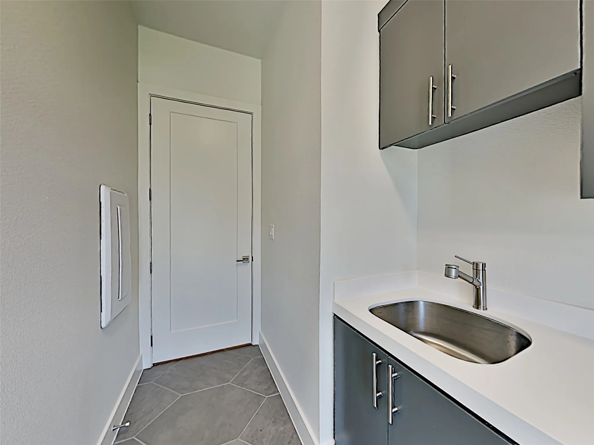 2nd floor laundry, full size washer dryer area, with sink and storage.