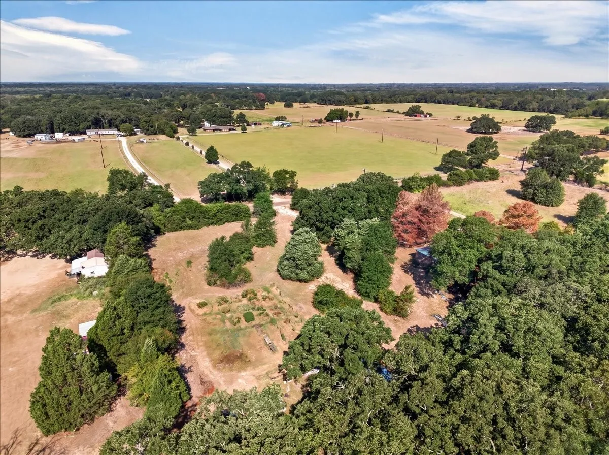 Expansive land featuring mature trees, open fields, and established clearings