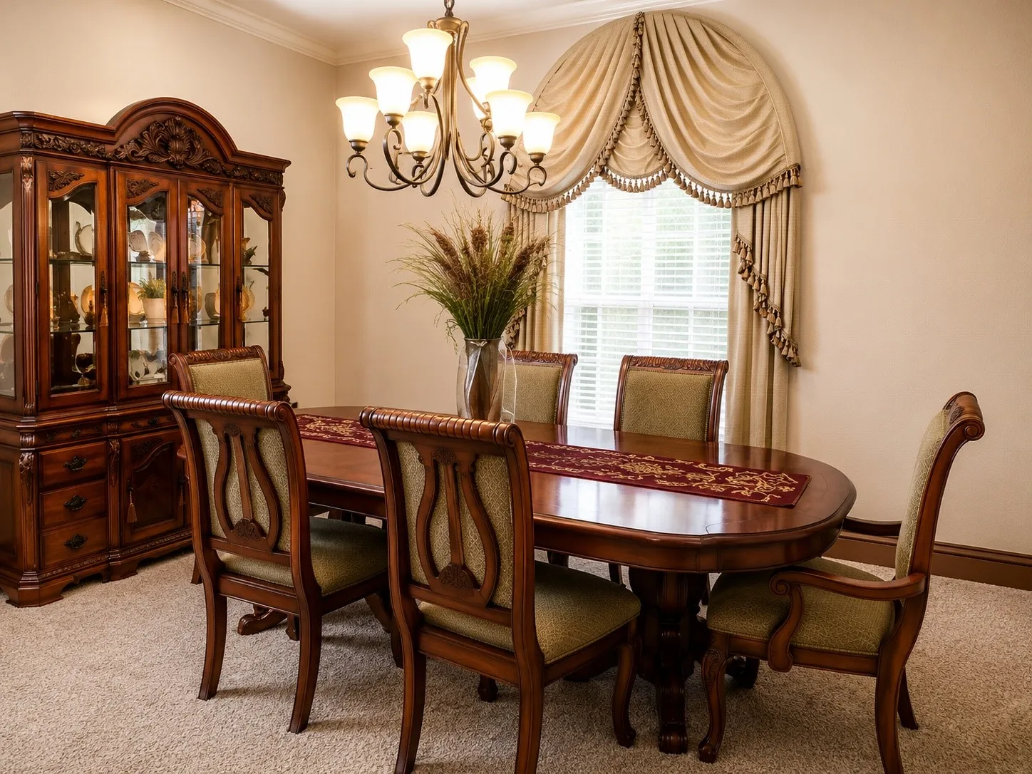 Elegant formal dining room showcasing a dark wood oval table with turned pedestal base, upholstered dining chairs with curved backs, and a coordinating china cabinet with glass-front doors and decorative hardware