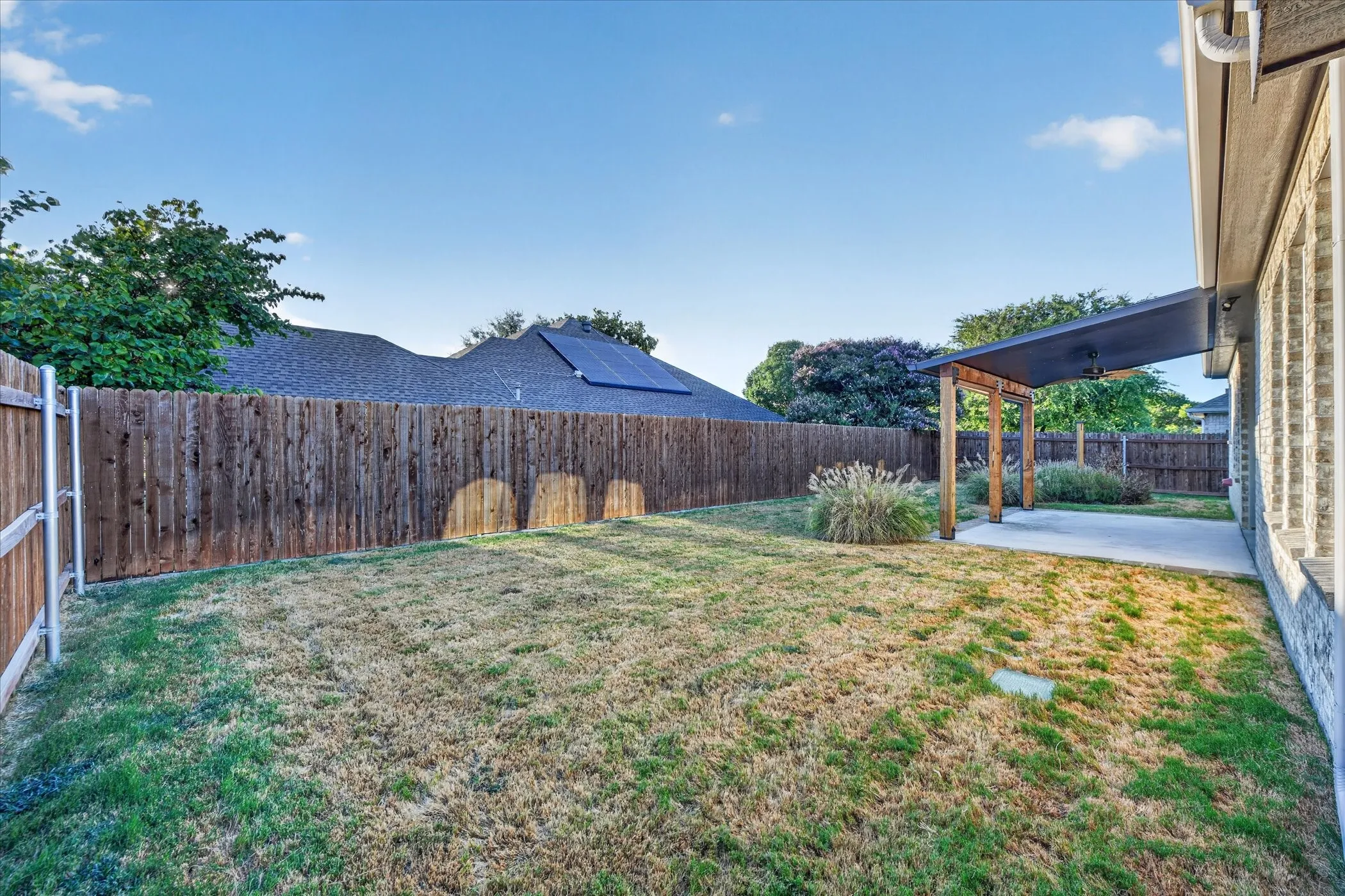 Private yard with perimeter fencing, a concrete patio, and an attached pergola