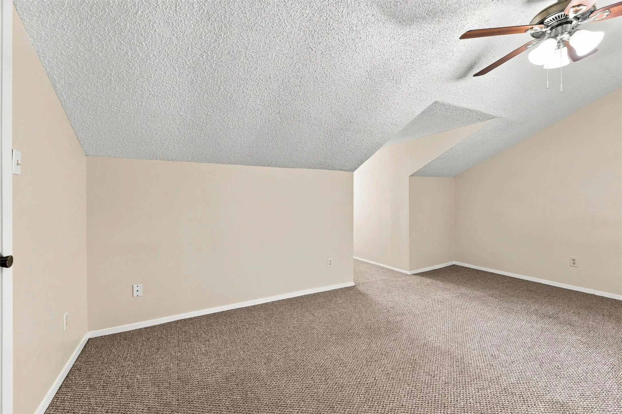 Vaulted ceiling, ceiling fan with integrated lighting, textured ceiling finish, neutral wall tones, and carpet flooring