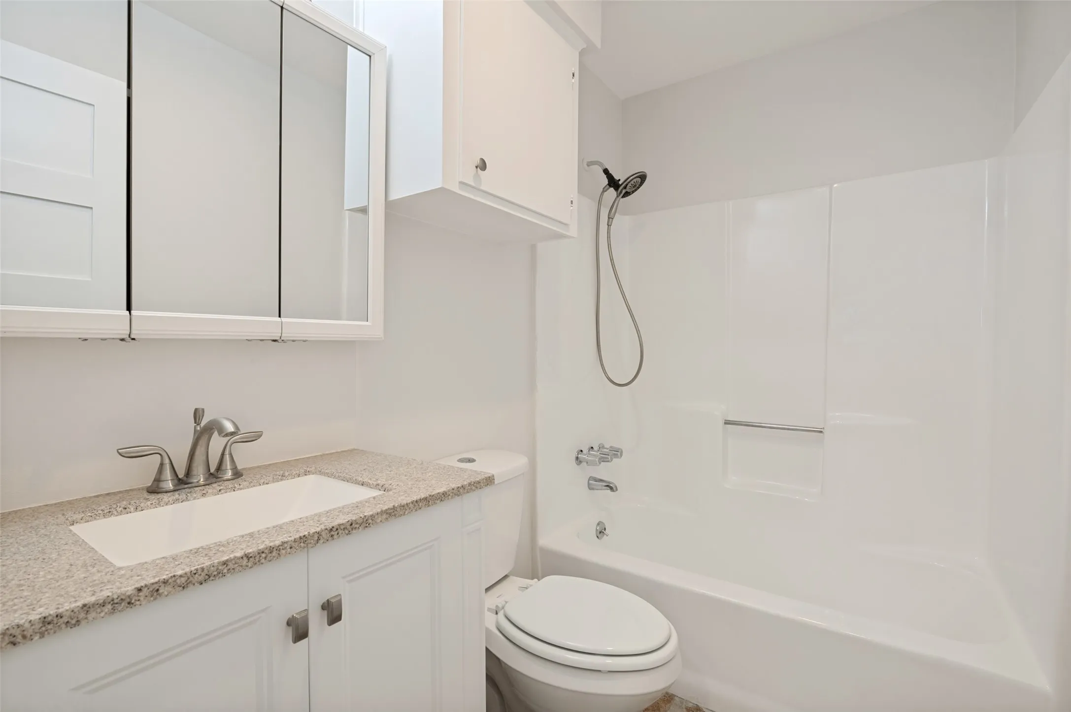 White vanity with light-toned countertop, undermount sink, and brushed nickel fixtures