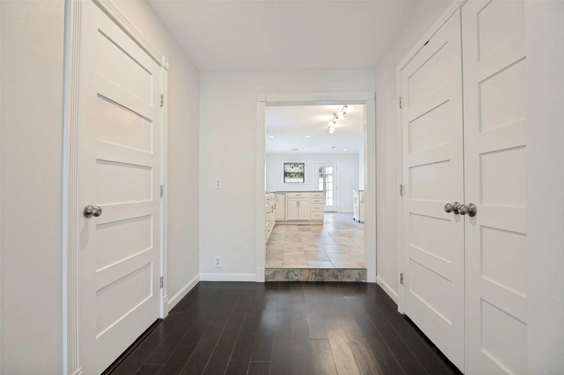 Dark wood-finish flooring with crisp white walls