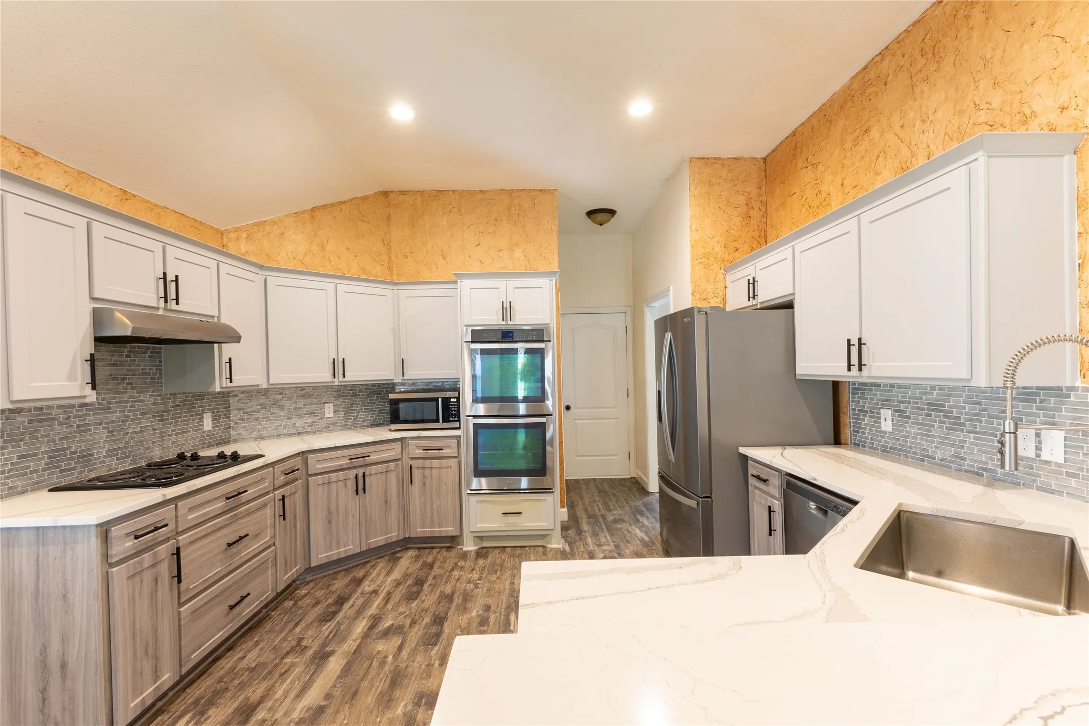 Kitchen has granite counters, stainless steel appliances.