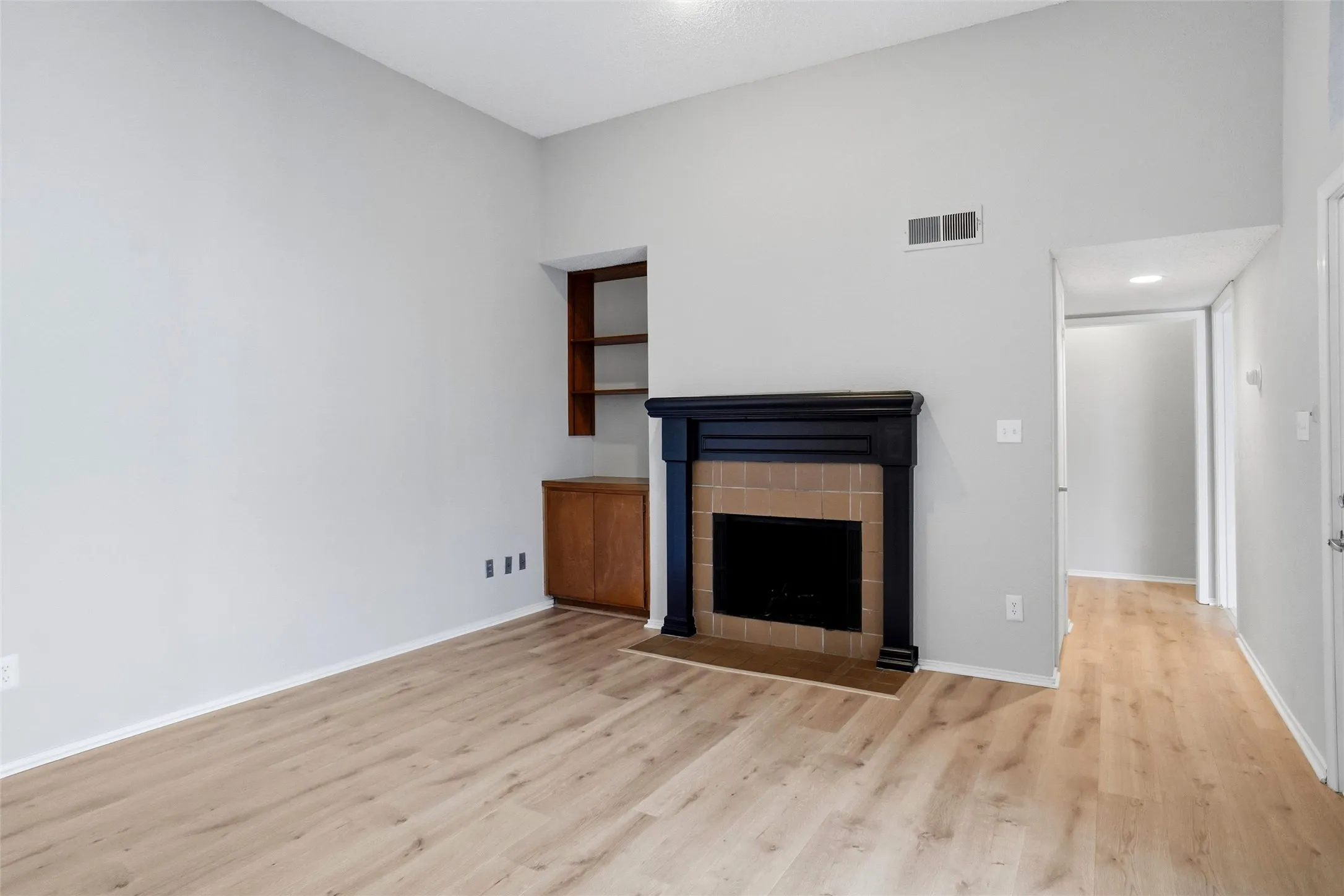 Another view of Living Room*LVP flooring throughout, fireplace, built-in shelves & cabinet