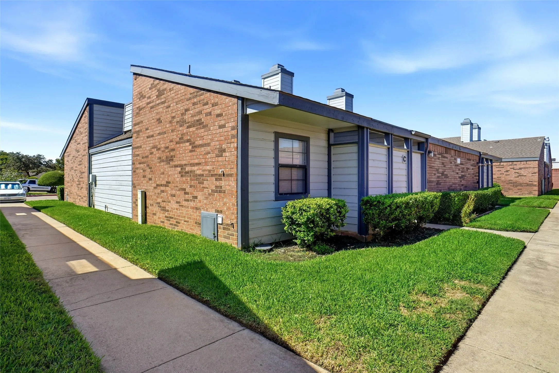 Brick and siding Exterior with concrete walkways and well manicured lawns