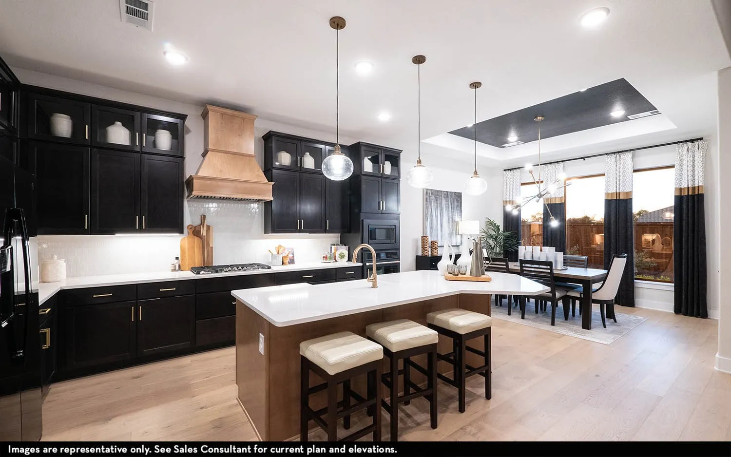 Gourmet kitchen with dark cabinetry, light countertops, wood-finish flooring, and a large central island