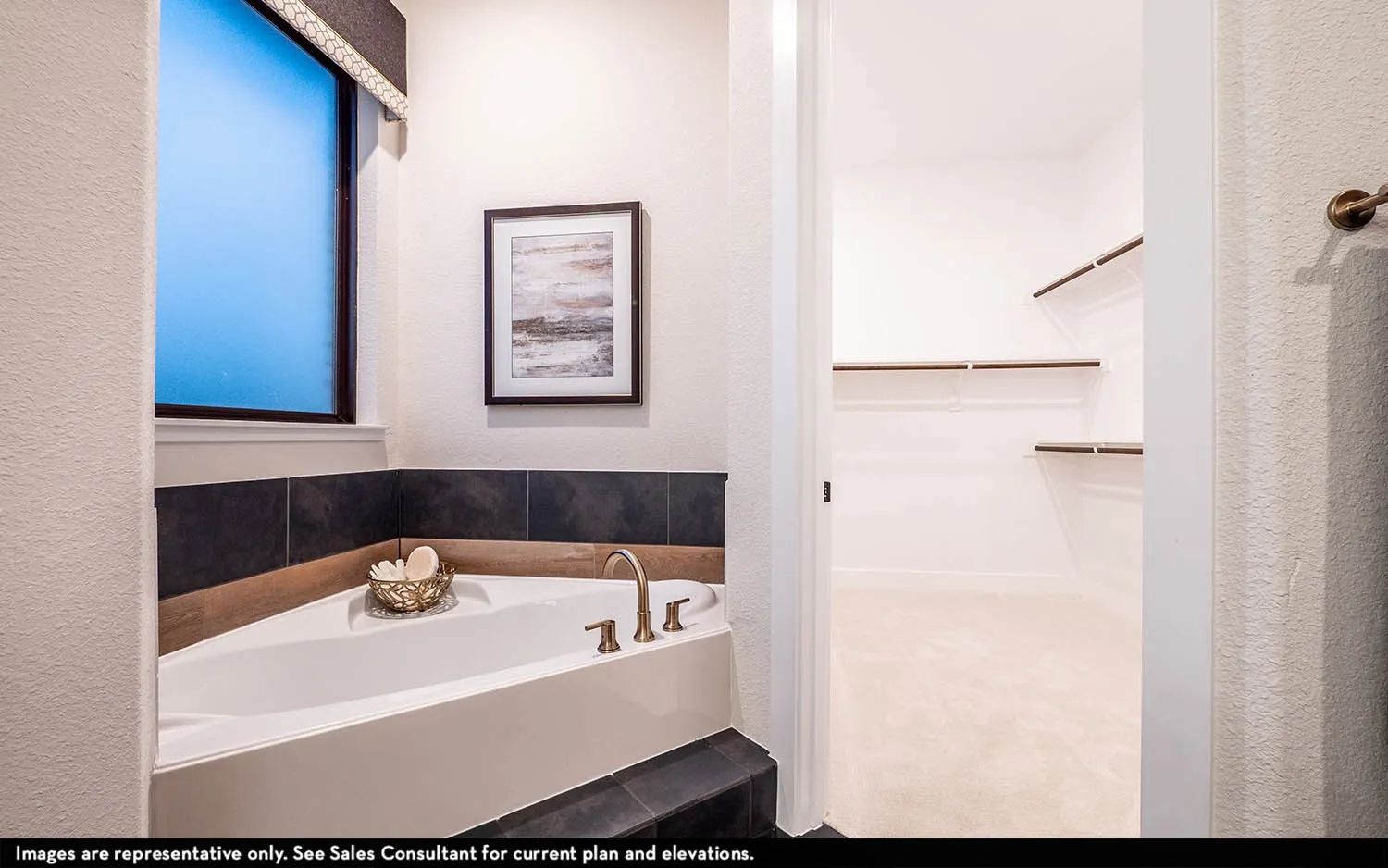 Corner built-in tub with dark tile surround and bronze-finish fixtures