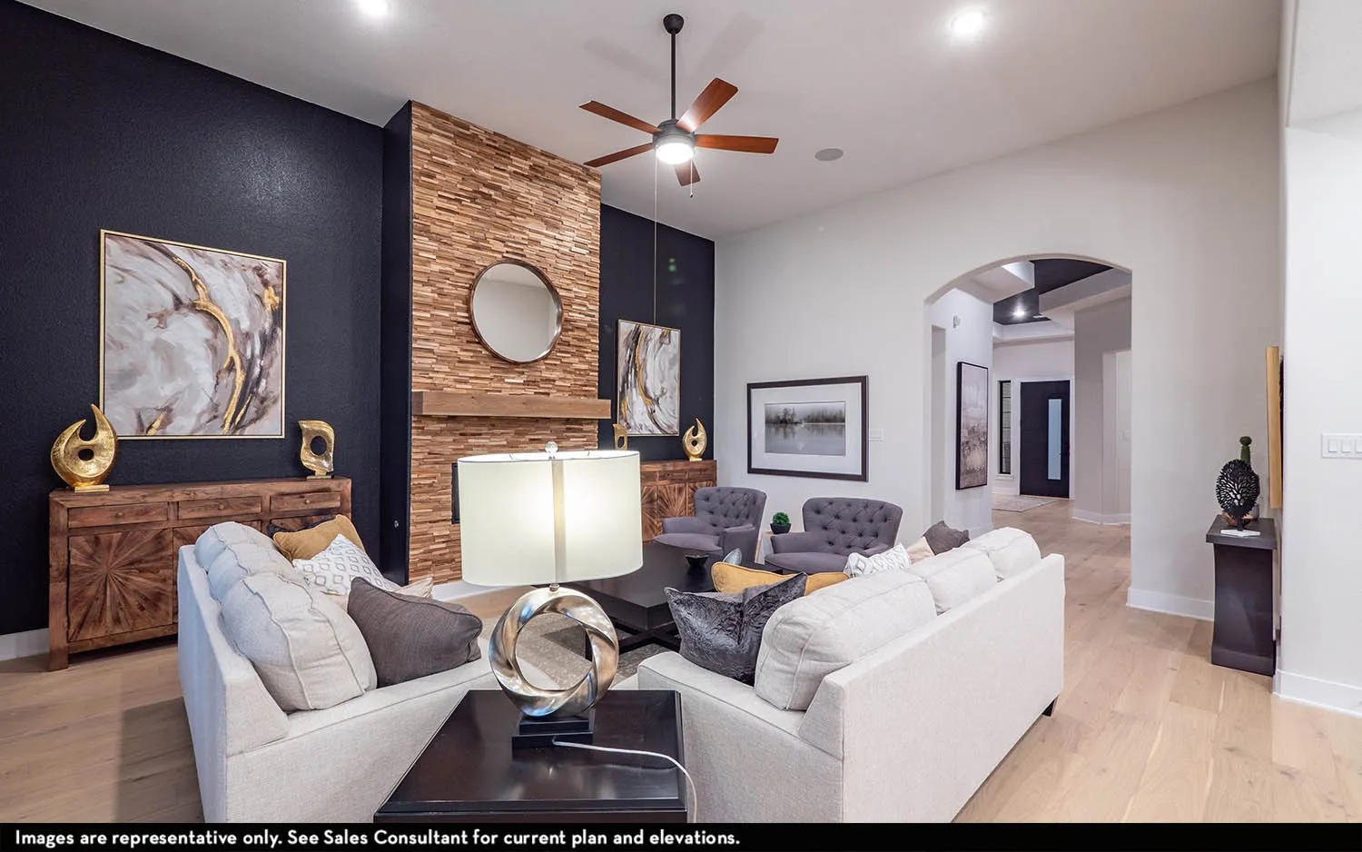 Vaulted ceilings, wood-finish flooring, wood-stacked stone fireplace with wood mantel, ceiling fan, and arched entryway