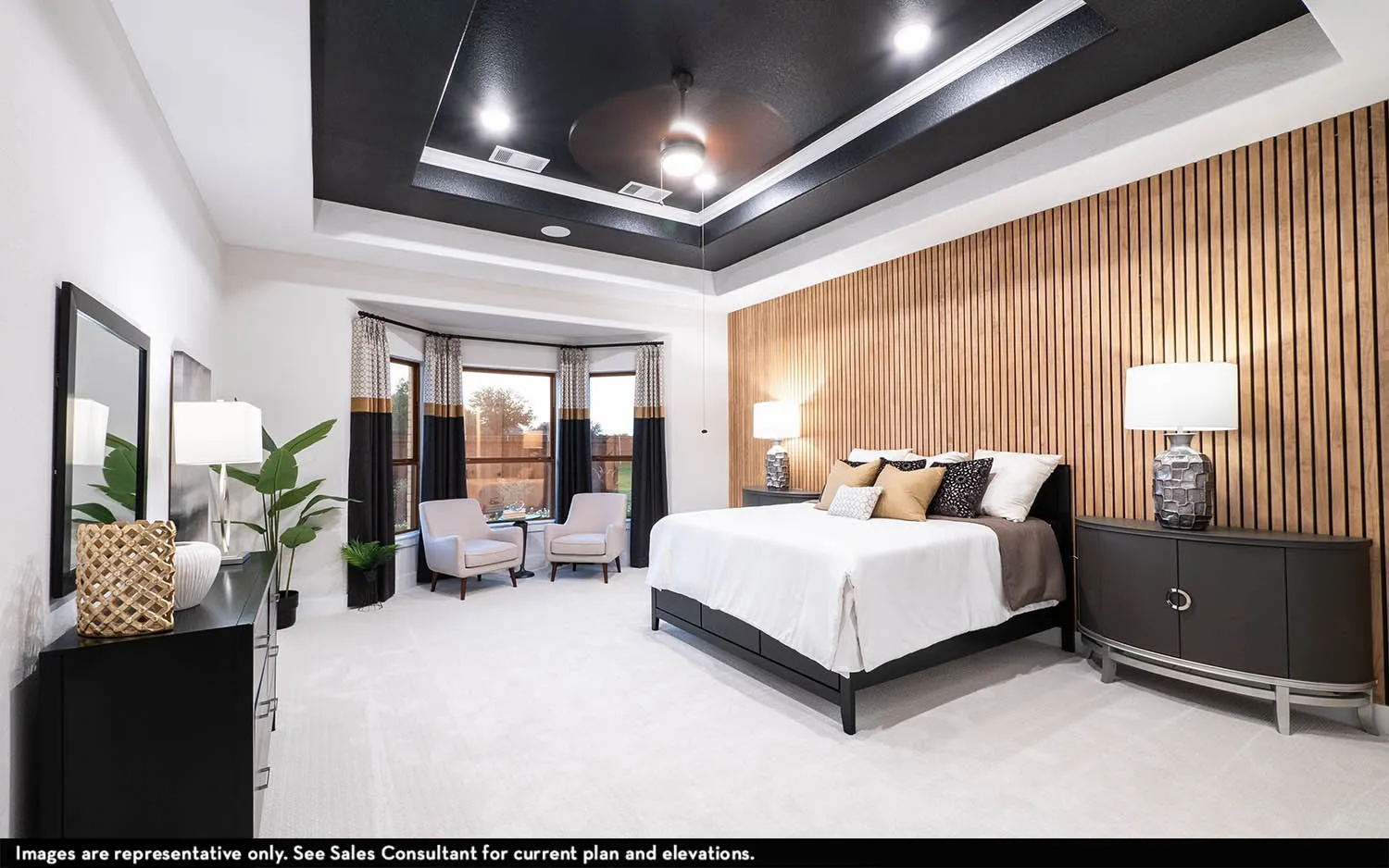 Tray ceiling with recessed lighting and ceiling fan, wood slat accent wall, bay window with multiple panes, and light-toned carpeting