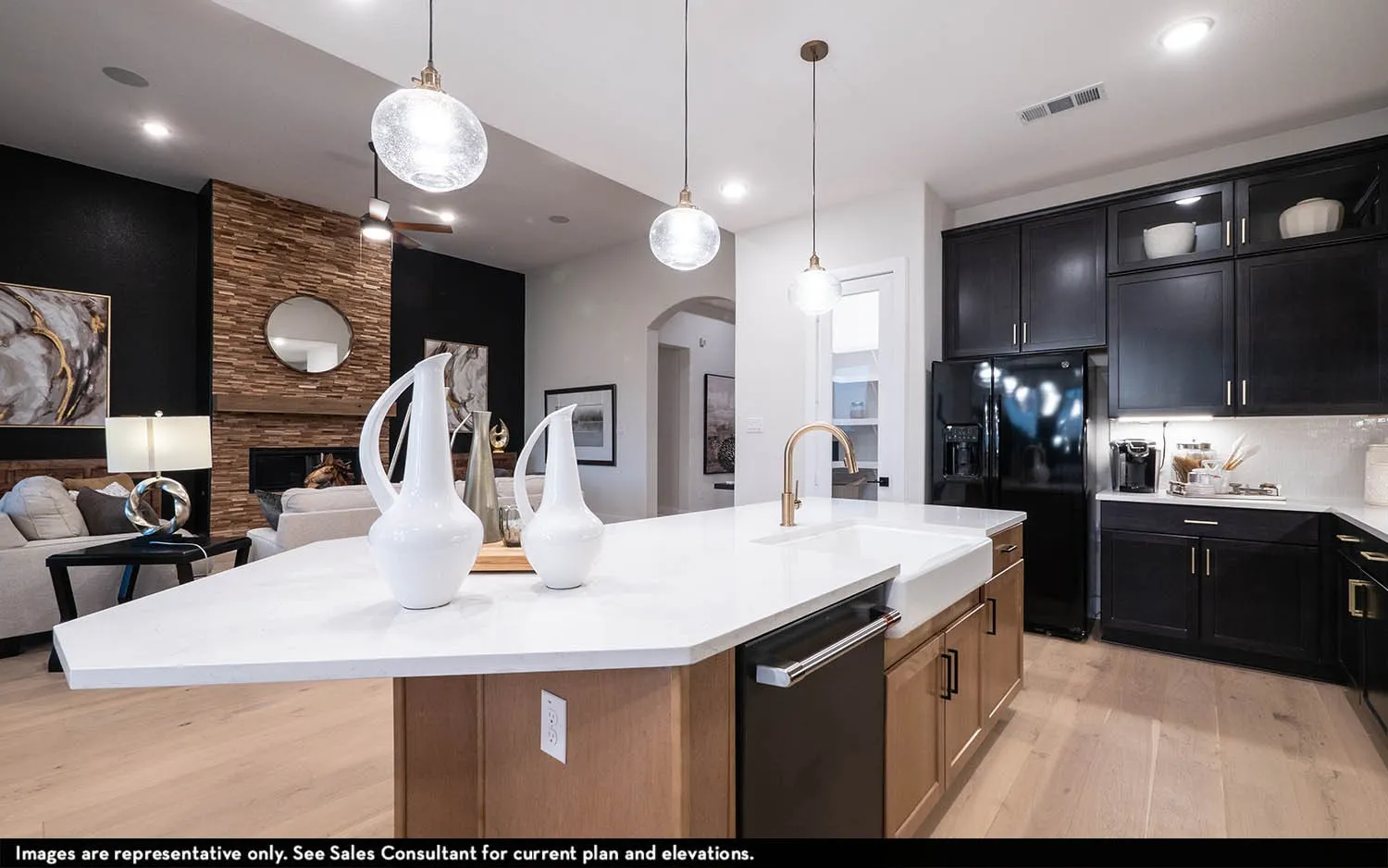 Kitchen featuring a white farmhouse sink, gold-tone faucet, dark cabinetry, and integrated appliances
