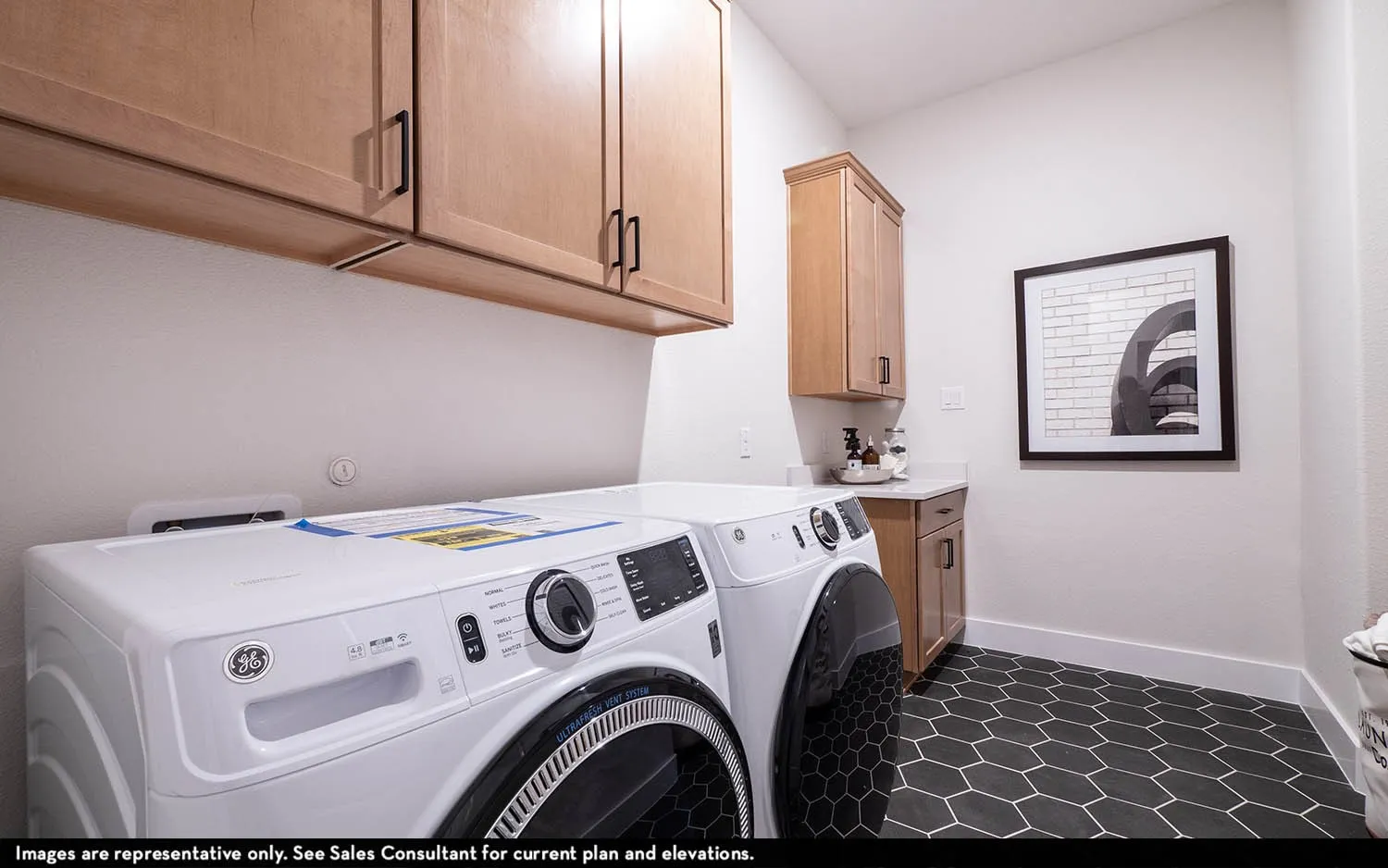 Hexagonal floor tiling, wood-finish cabinetry, built-in countertop, and white wall finishes