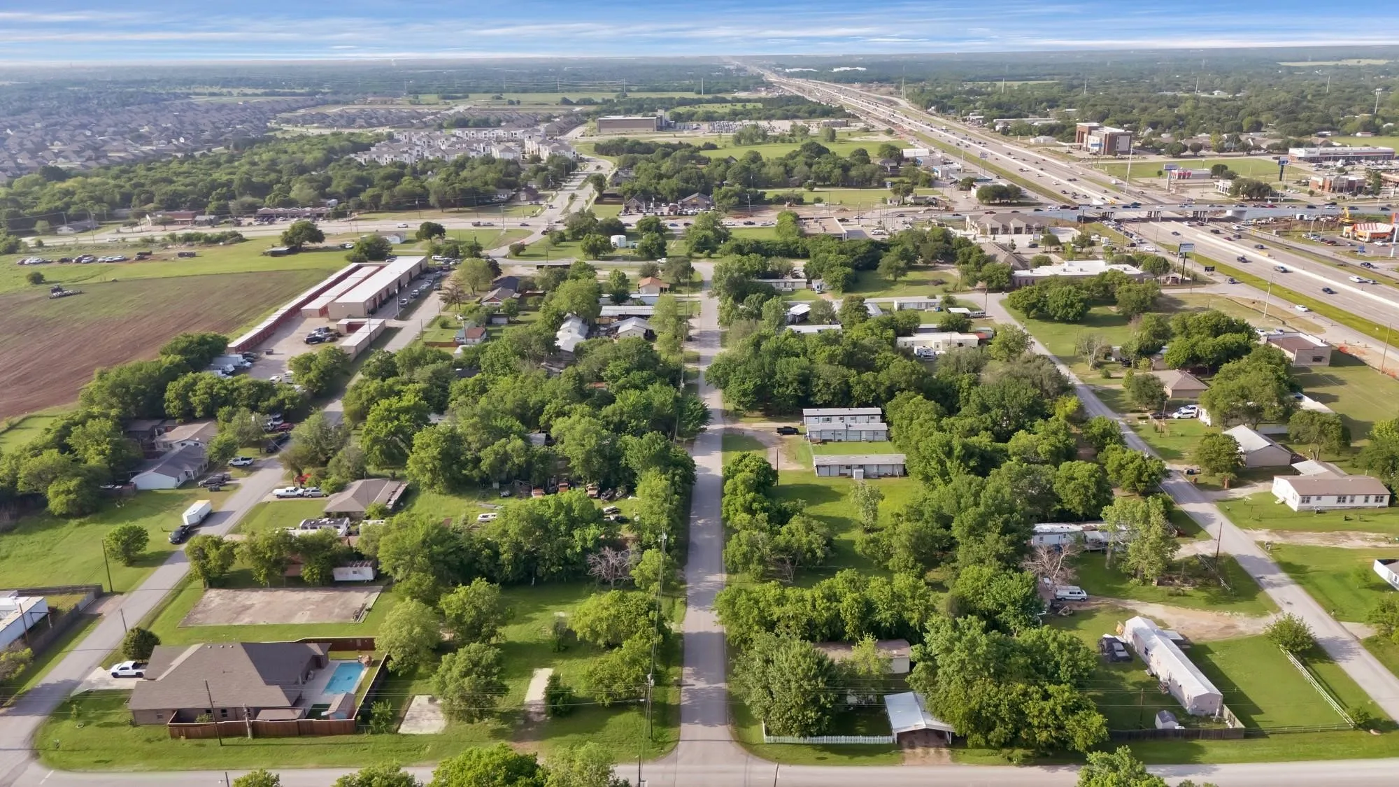 Aerial view of property's location with a highway and nearby suburban area