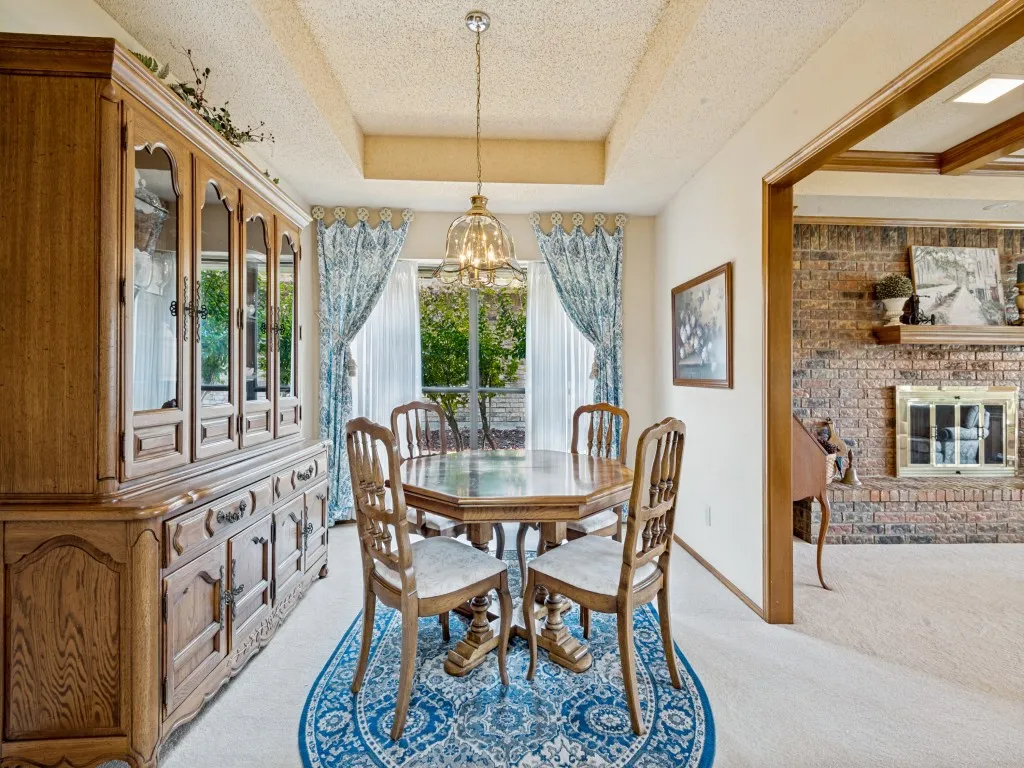 This dining space features a bay window that opens to colorful landscaping.