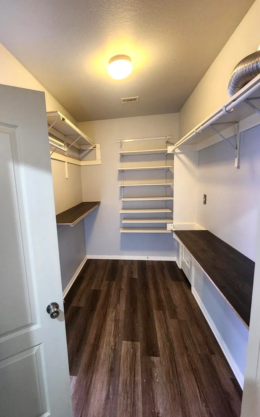 Dedicated utility room featuring plank flooring, built-in shelving, and integrated countertops