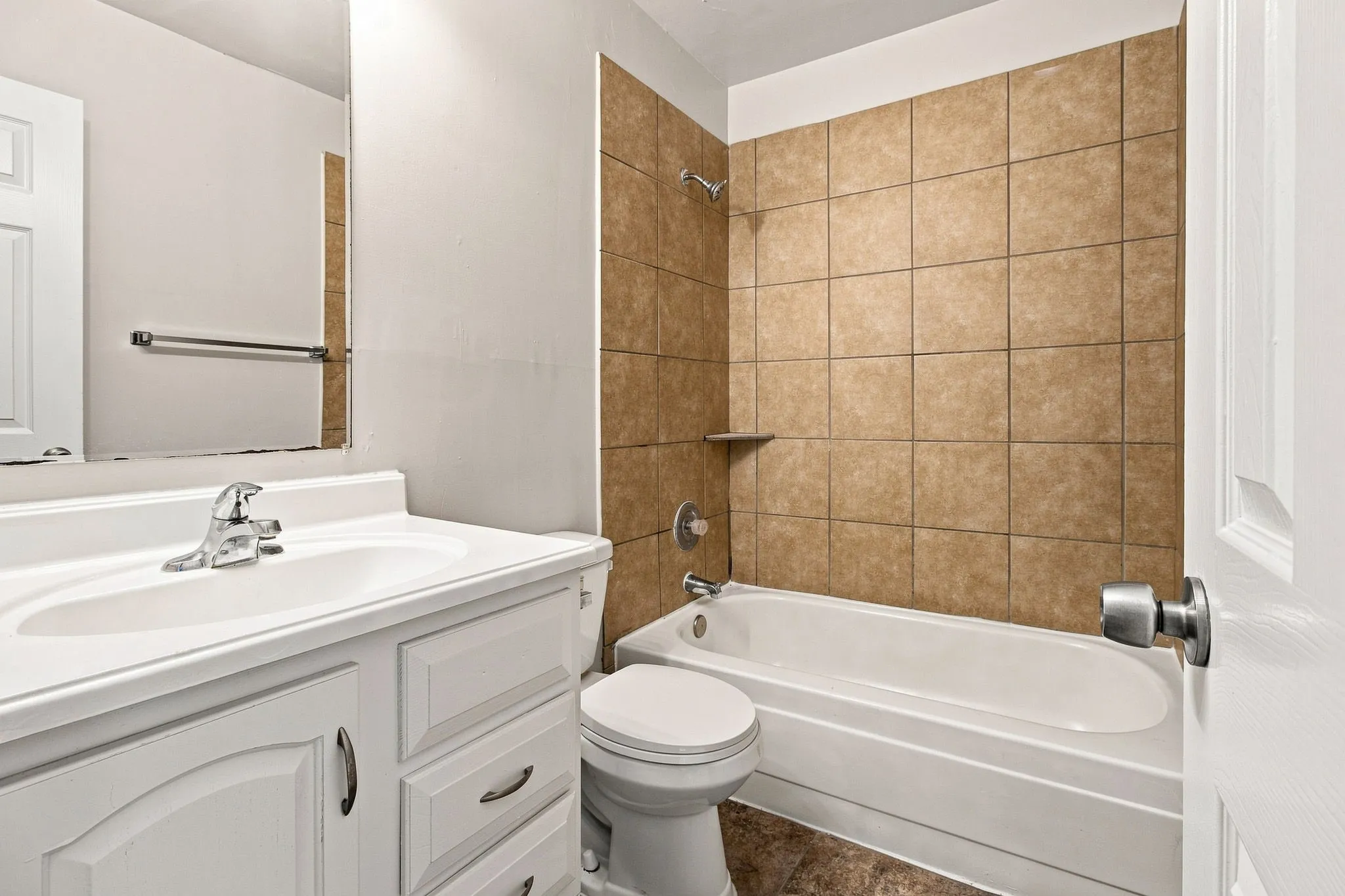 White vanity with a single basin sink, chrome faucet, and storage cabinetry