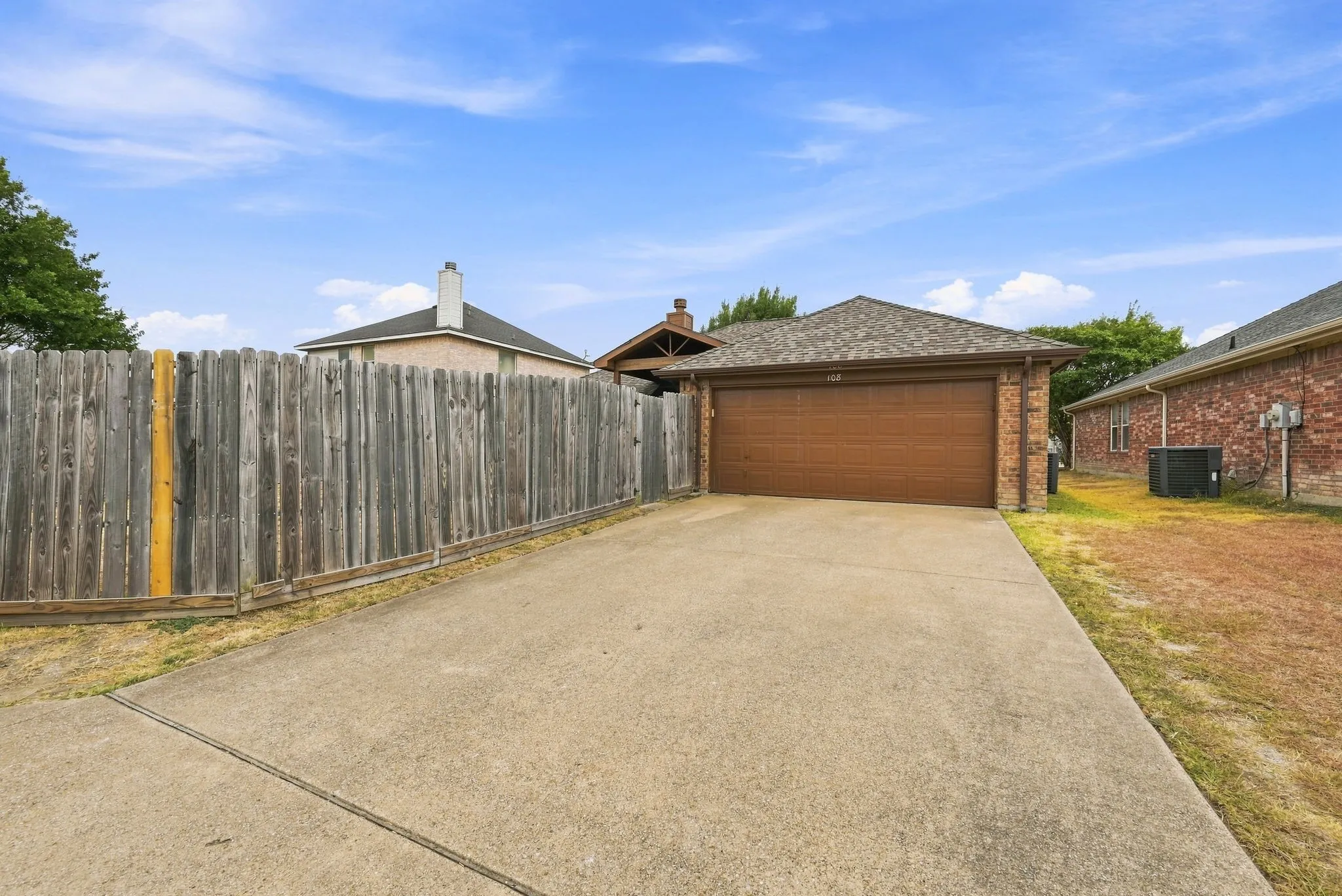 Brick exterior with an attached garage and concrete driveway