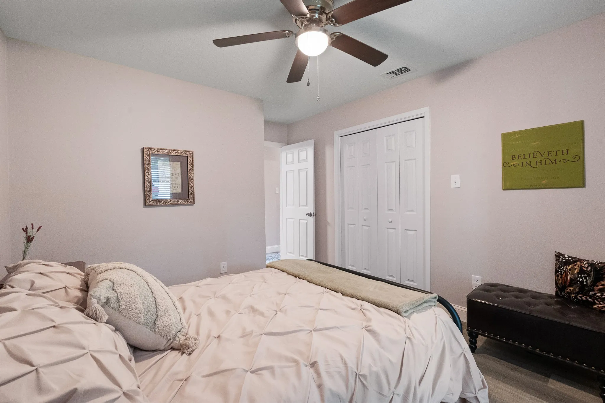 Ceiling fan with integrated lighting, wood-finish flooring, and panel doors