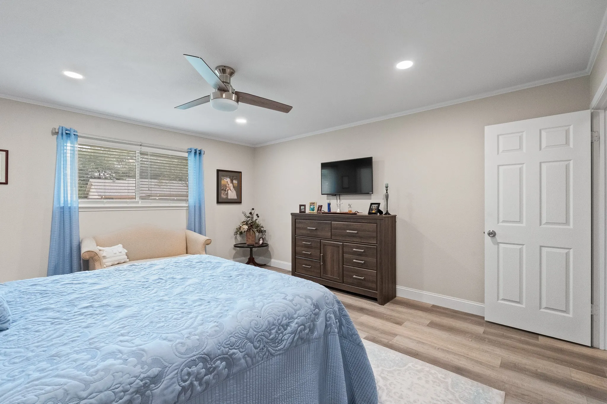 Recessed lighting, ceiling fan, wood-finish flooring, white trim, and a paneled door