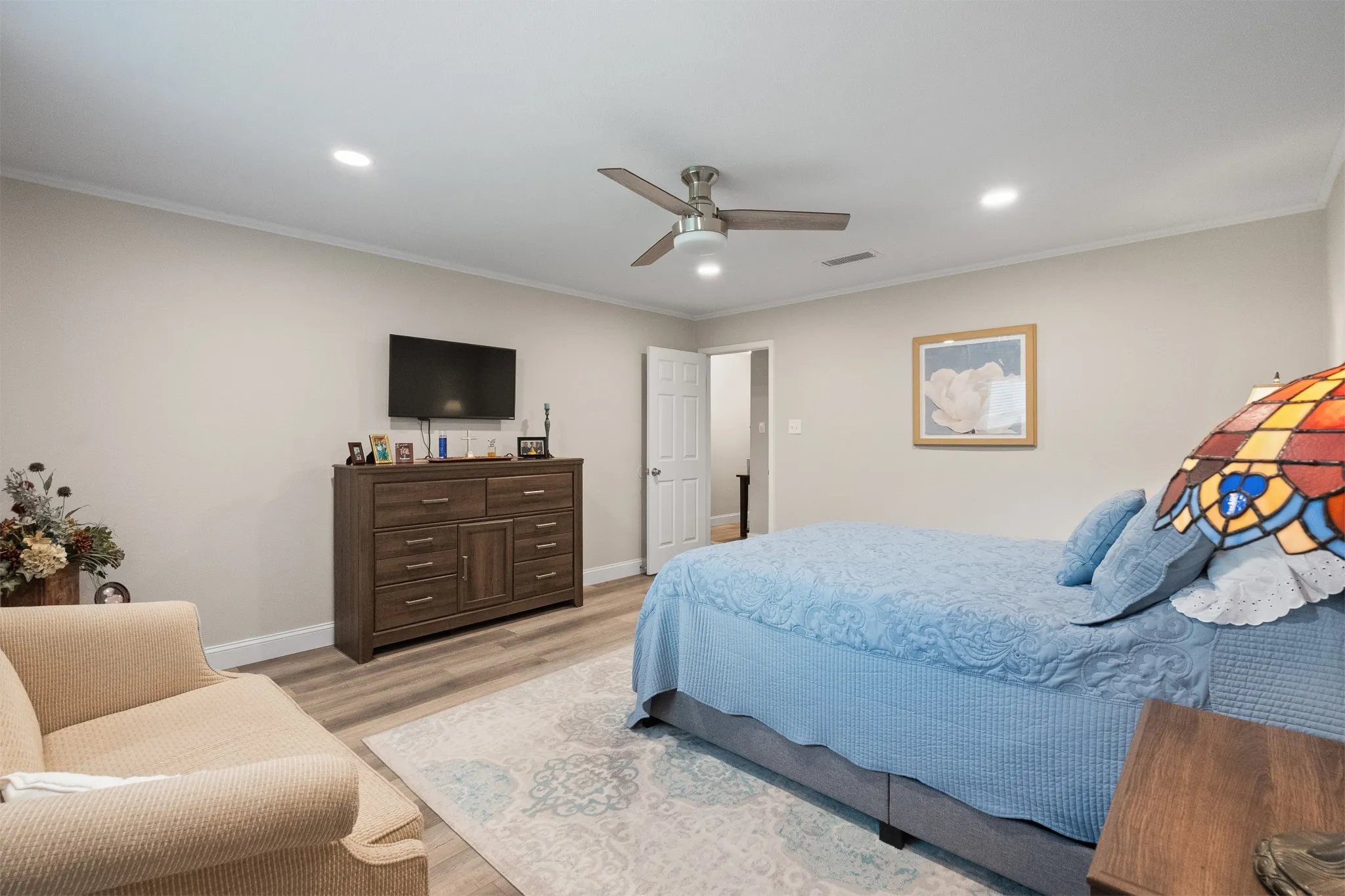Recessed lighting, crown molding, ceiling fan, wood-finish flooring, and a paneled interior door