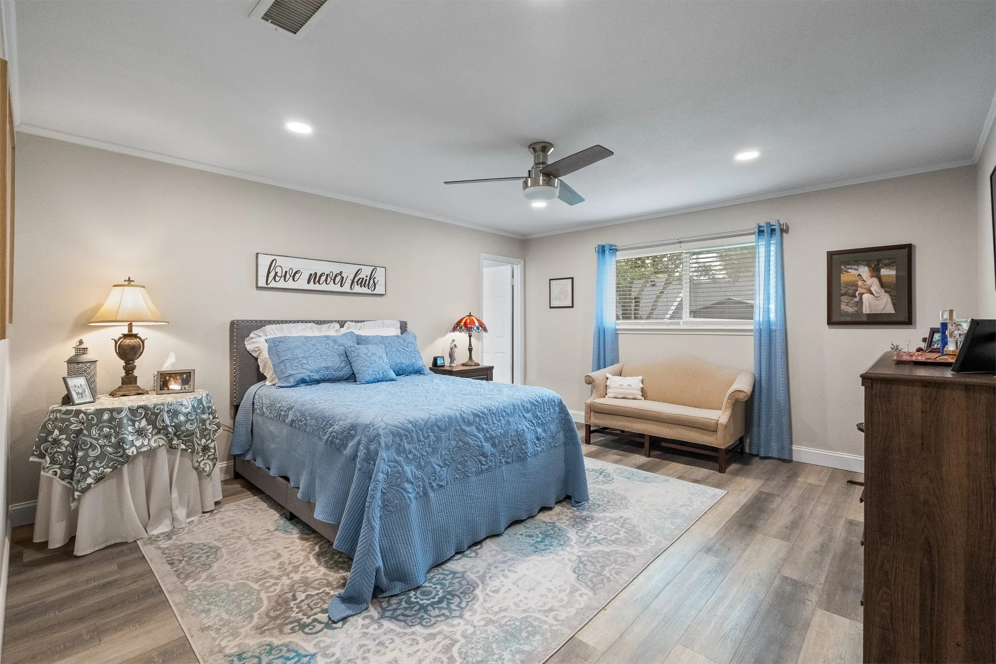 Spacious room featuring wood-finish flooring, a window with horizontal blinds, a ceiling fan with integrated lighting, and recessed ceiling lights