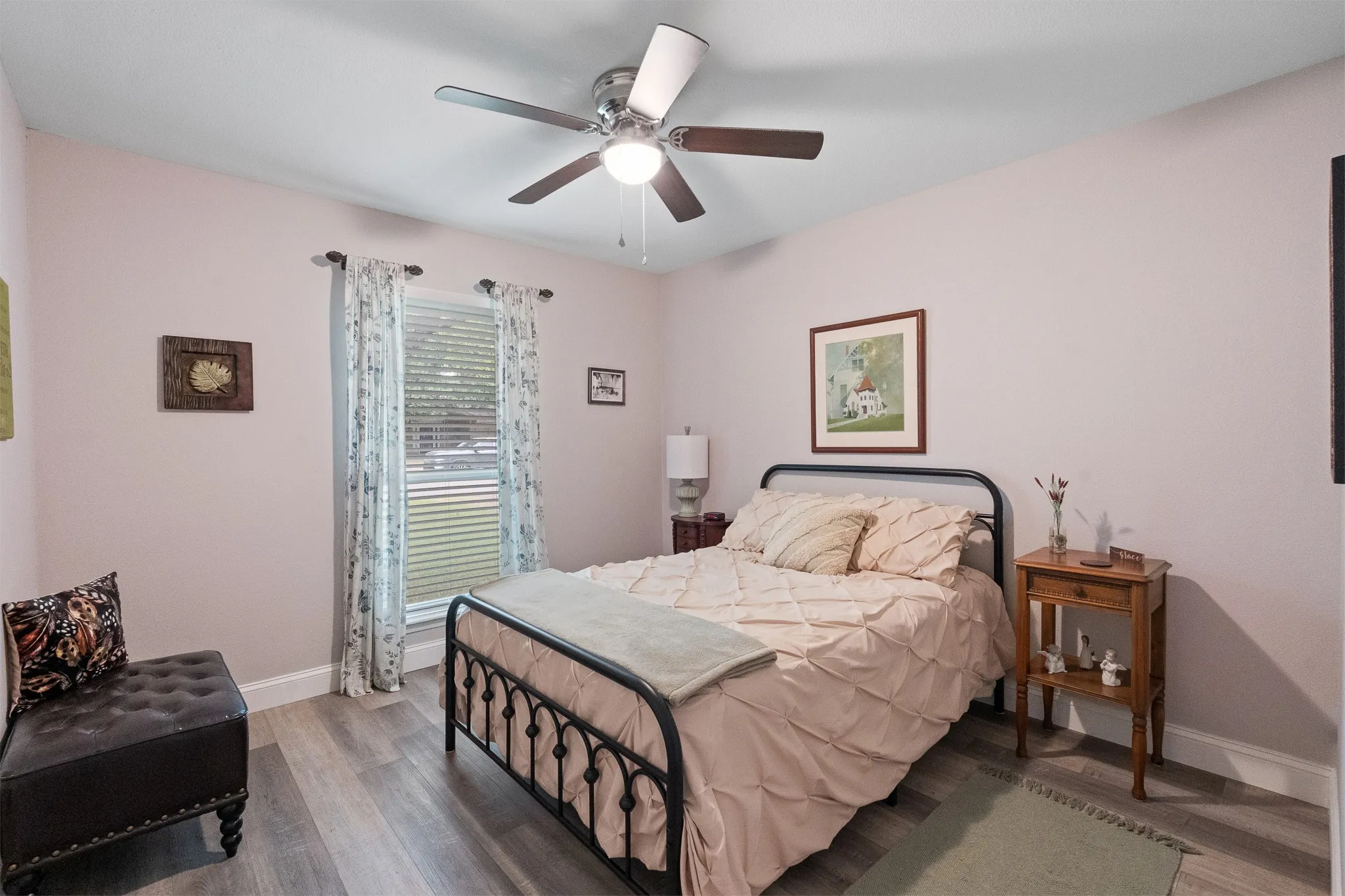 Neutral wall finishes, wood-finish flooring, a ceiling fan with integrated lighting, and a window with blinds