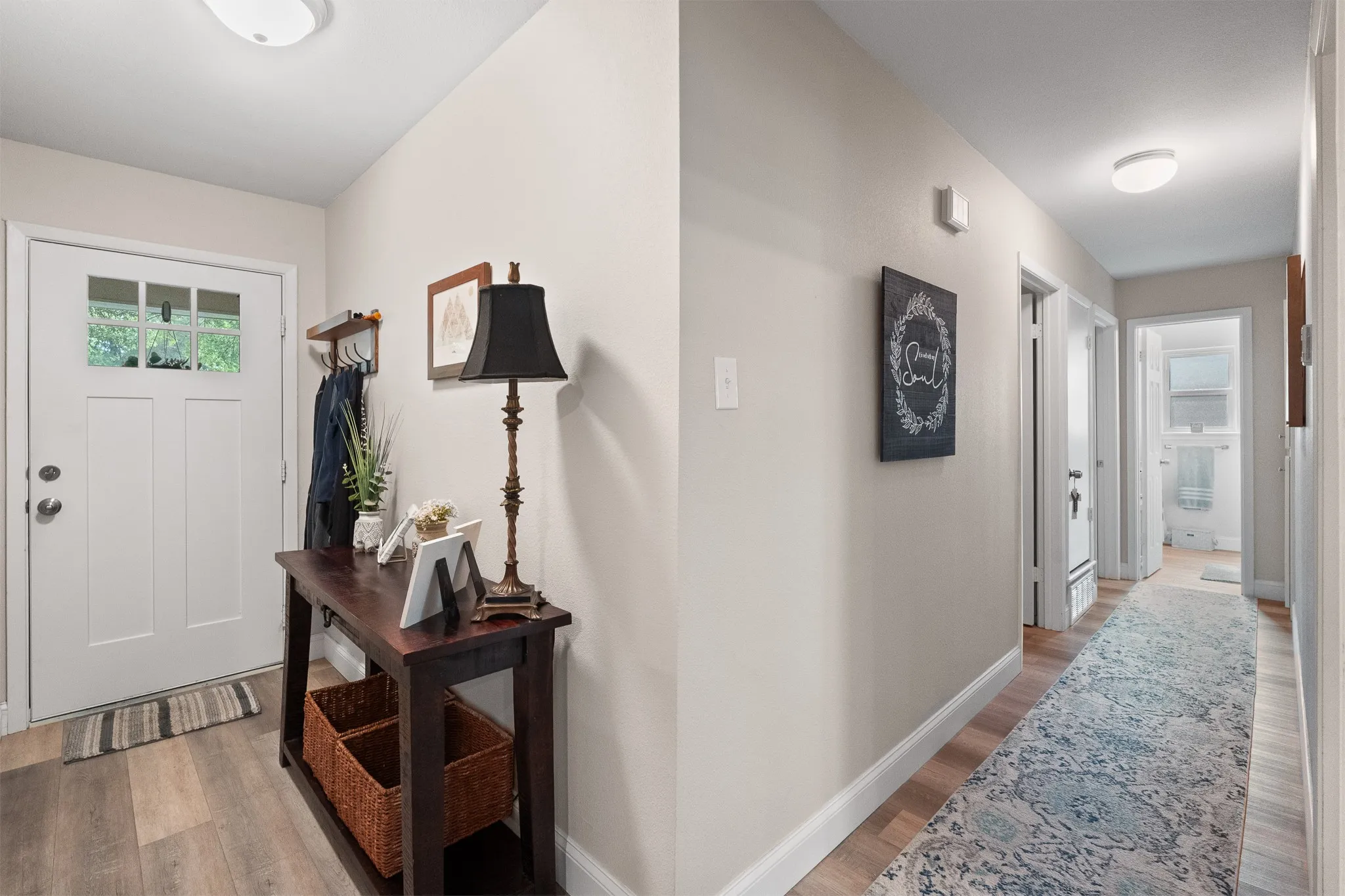 Wood-finish flooring throughout, white interior doors, and overhead lighting fixtures