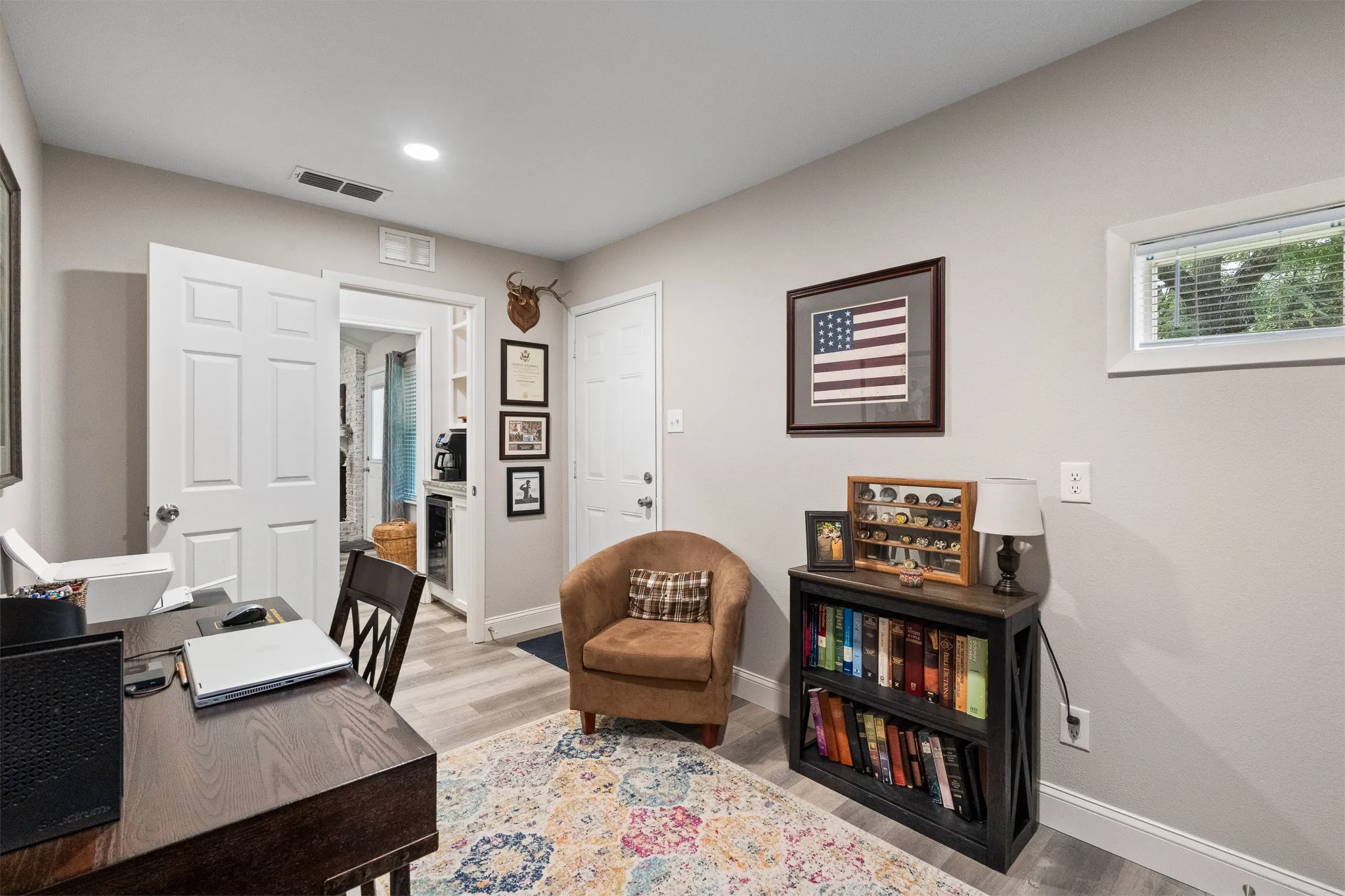 Recessed ceiling lighting, wood-finish flooring, white trim, and a window with blinds