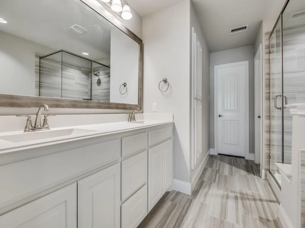 Double vanity with undermount sinks, white cabinetry, and brushed nickel fixtures