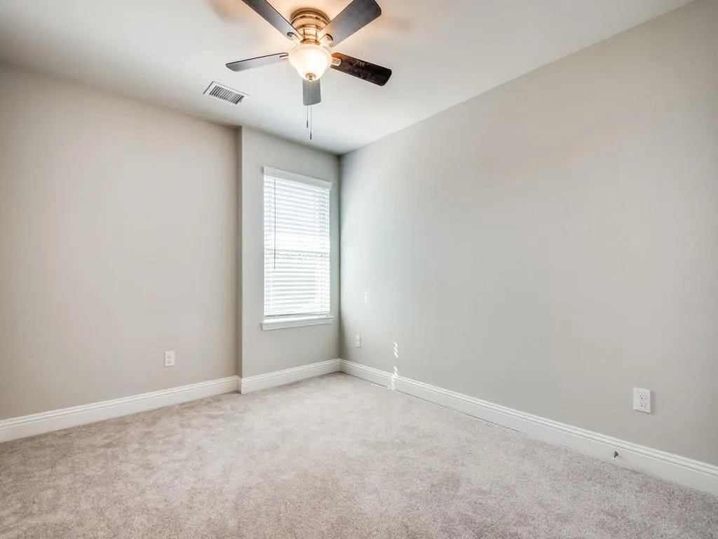 Neutral wall tones with carpet flooring and window with blinds
