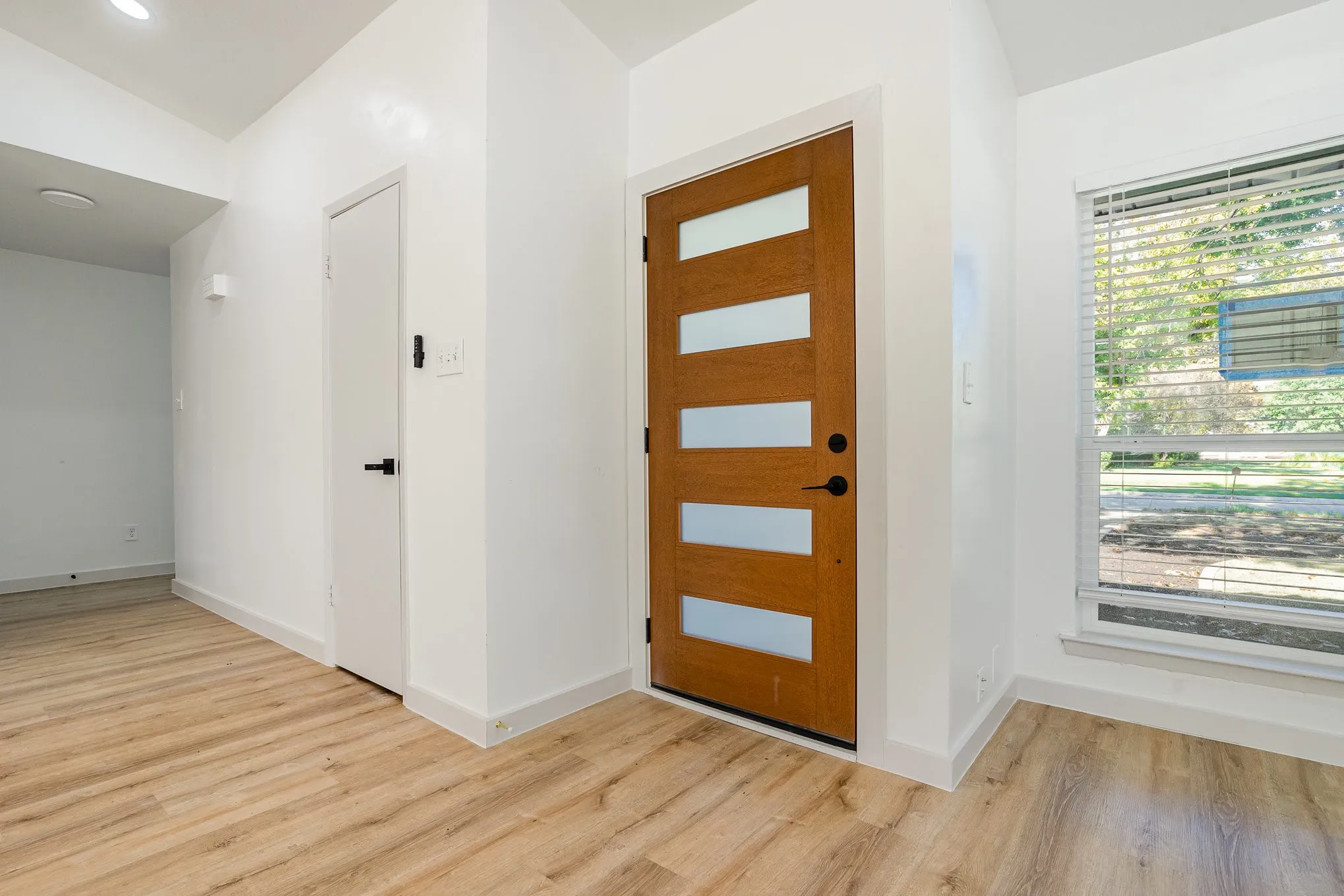Foyer featuring light hardwood / wood-style floors and vaulted ceiling