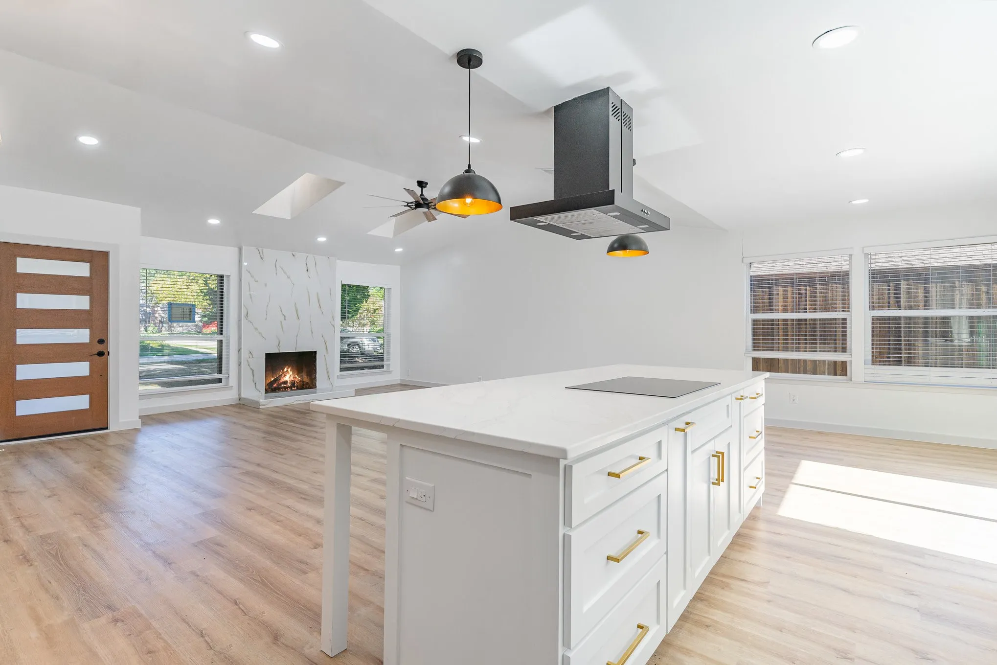 Kitchen featuring white cabinetry, a center island, a high end fireplace, island exhaust hood, and light wood-type flooring