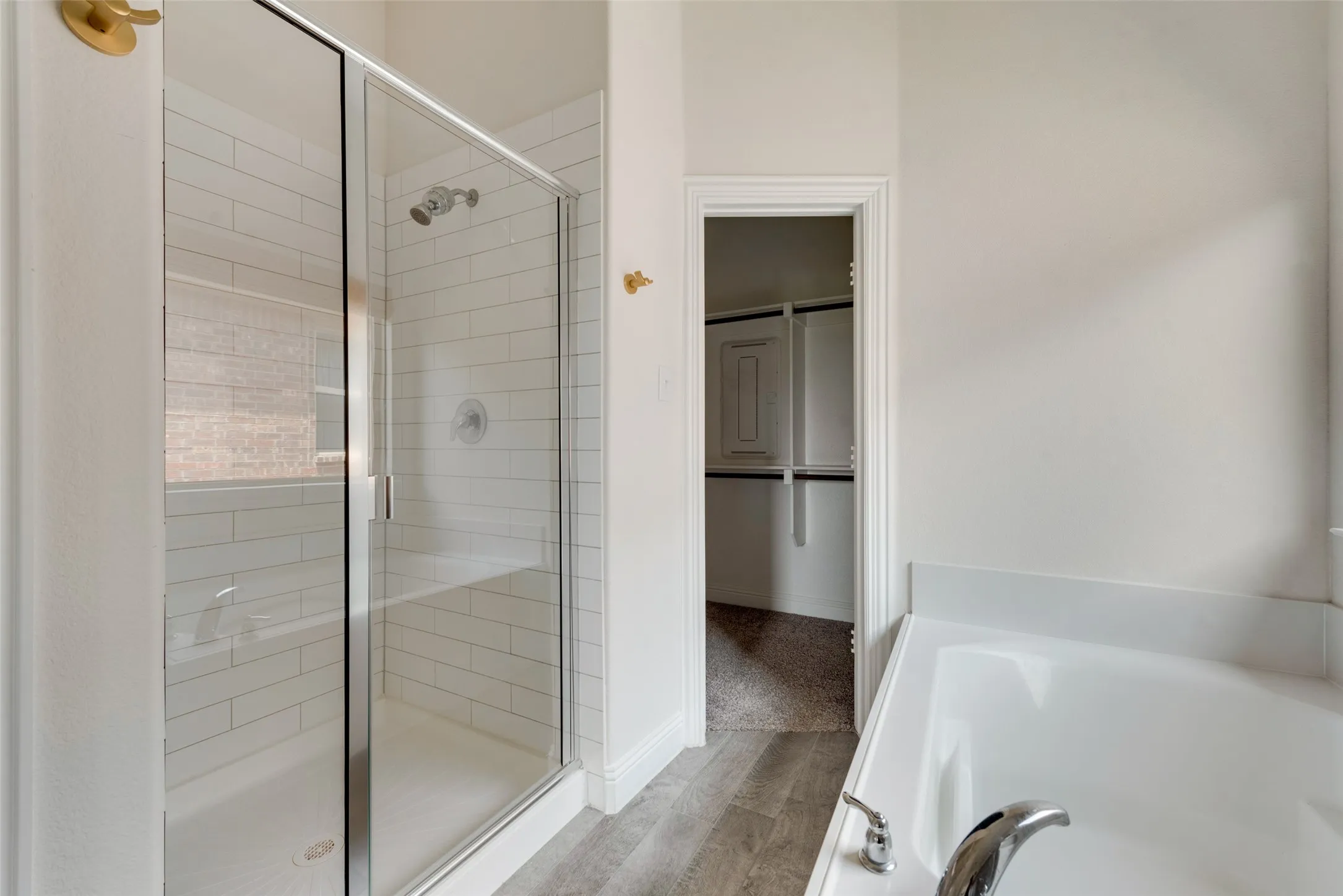 Bathroom featuring shower with separate bathtub and hardwood / wood-style flooring