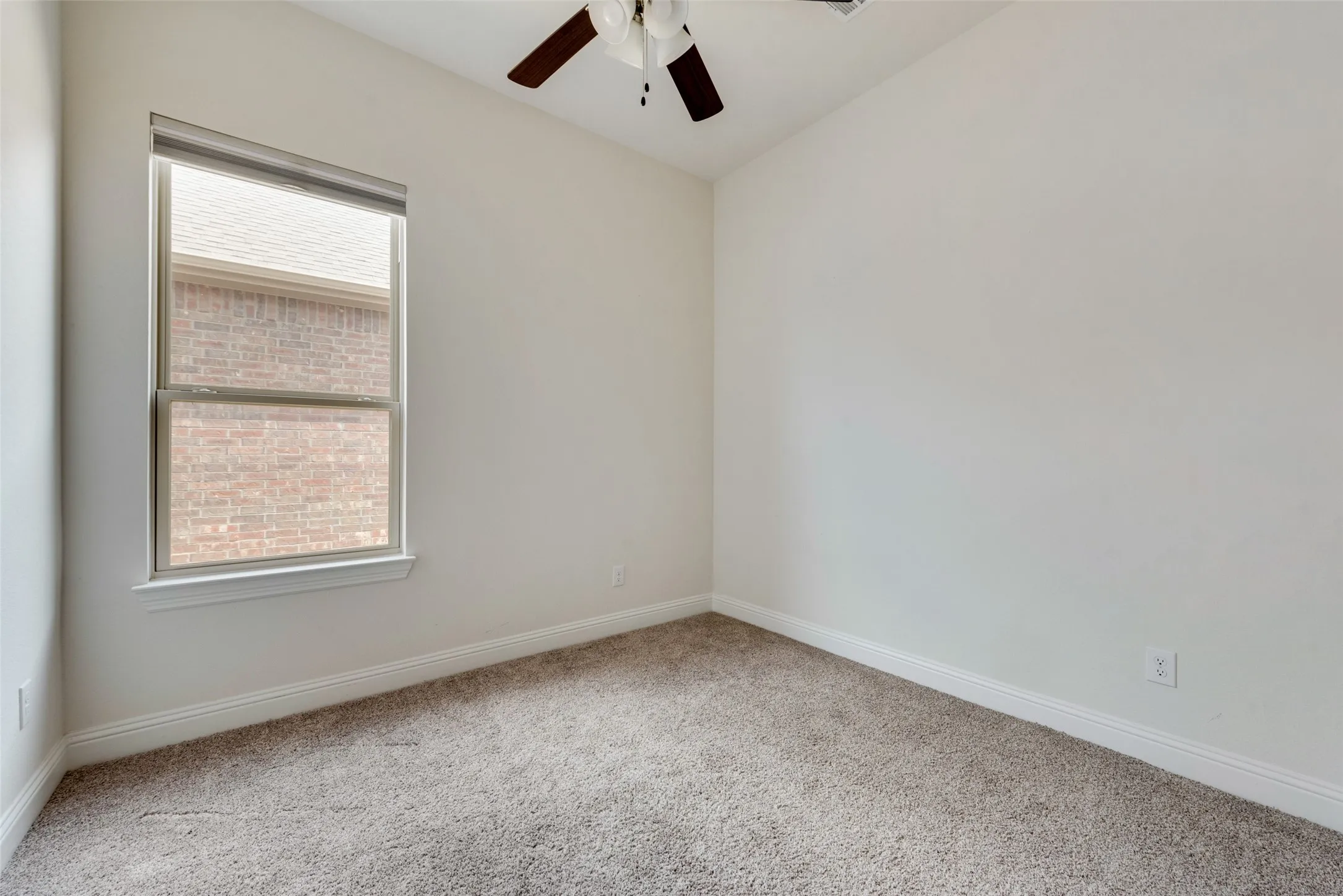 Carpeted empty room featuring ceiling fan and a healthy amount of sunlight
