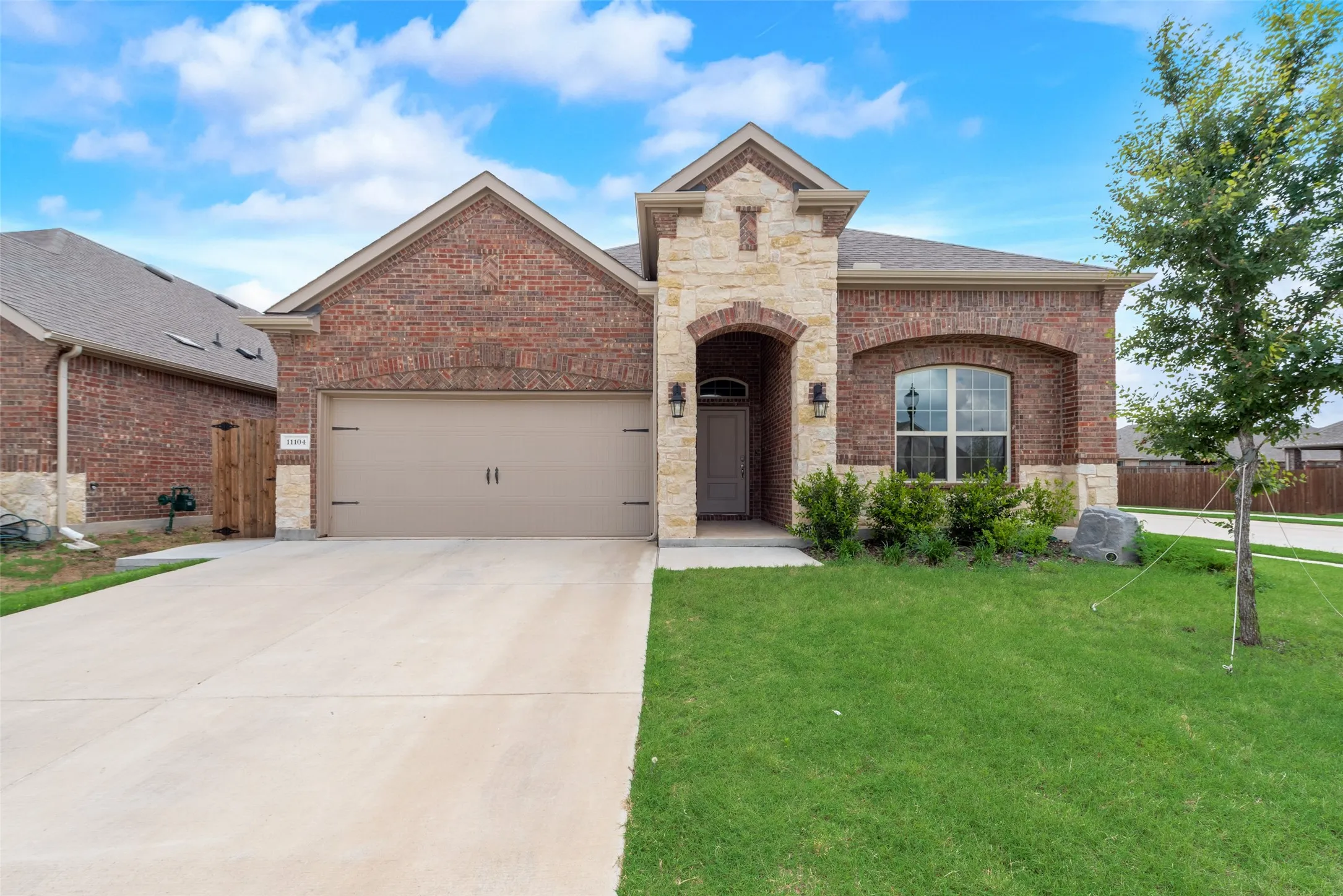 View of front facade featuring a garage and a front lawn