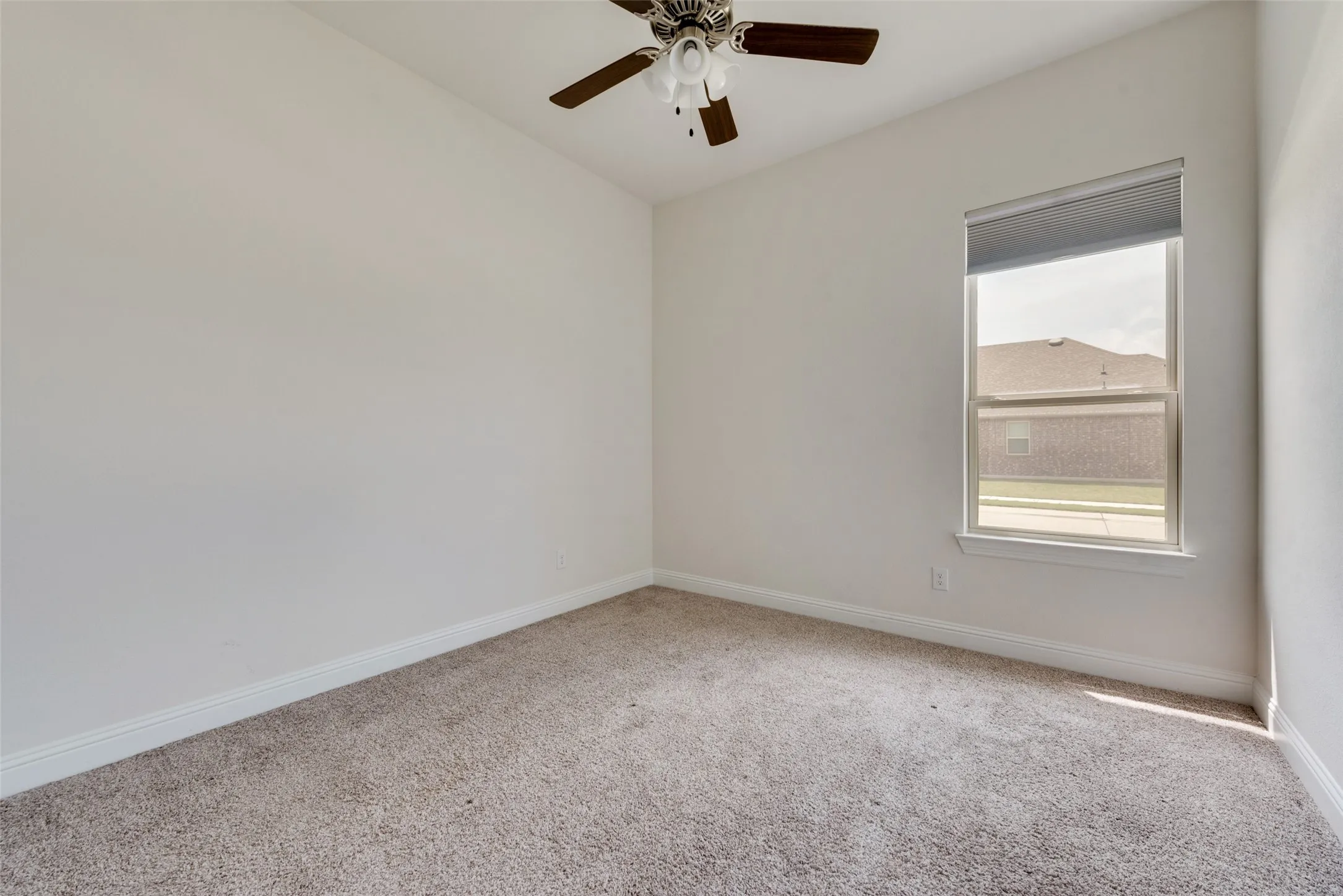 Carpeted empty room with ceiling fan