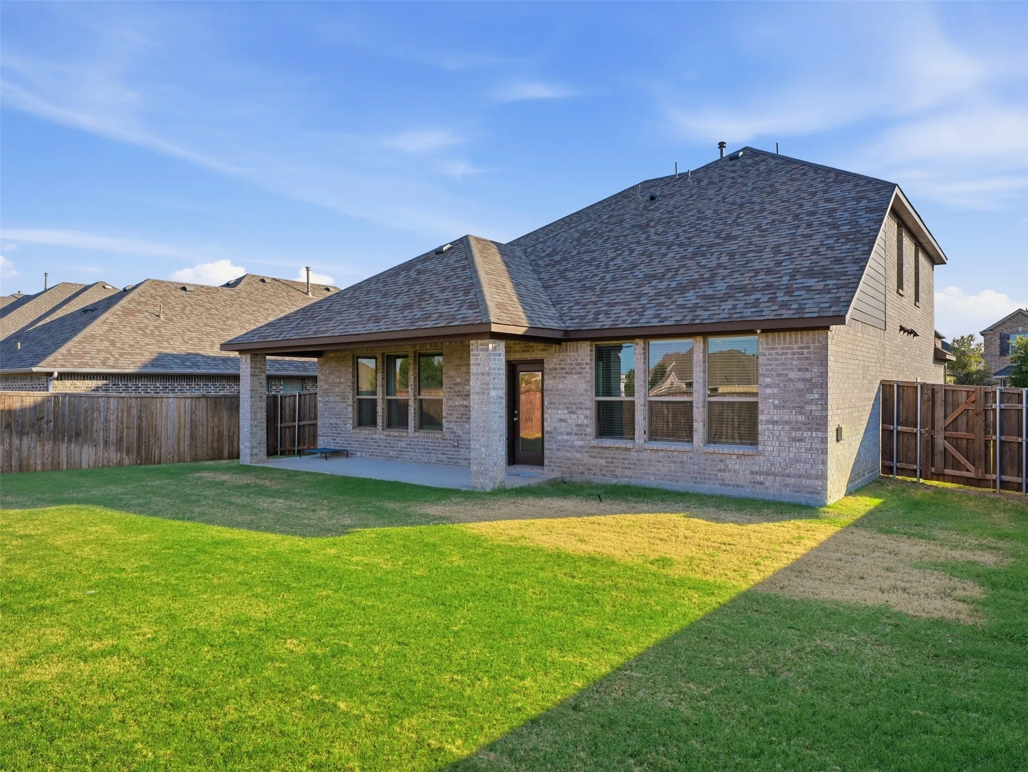 Exterior brick construction with a dark asphalt shingle roof