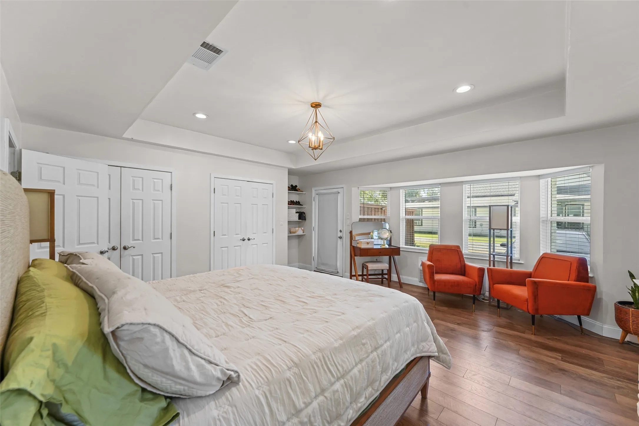 Wood-finish flooring, recessed lighting, ceiling light fixture, bay window with blinds, and white panel doors