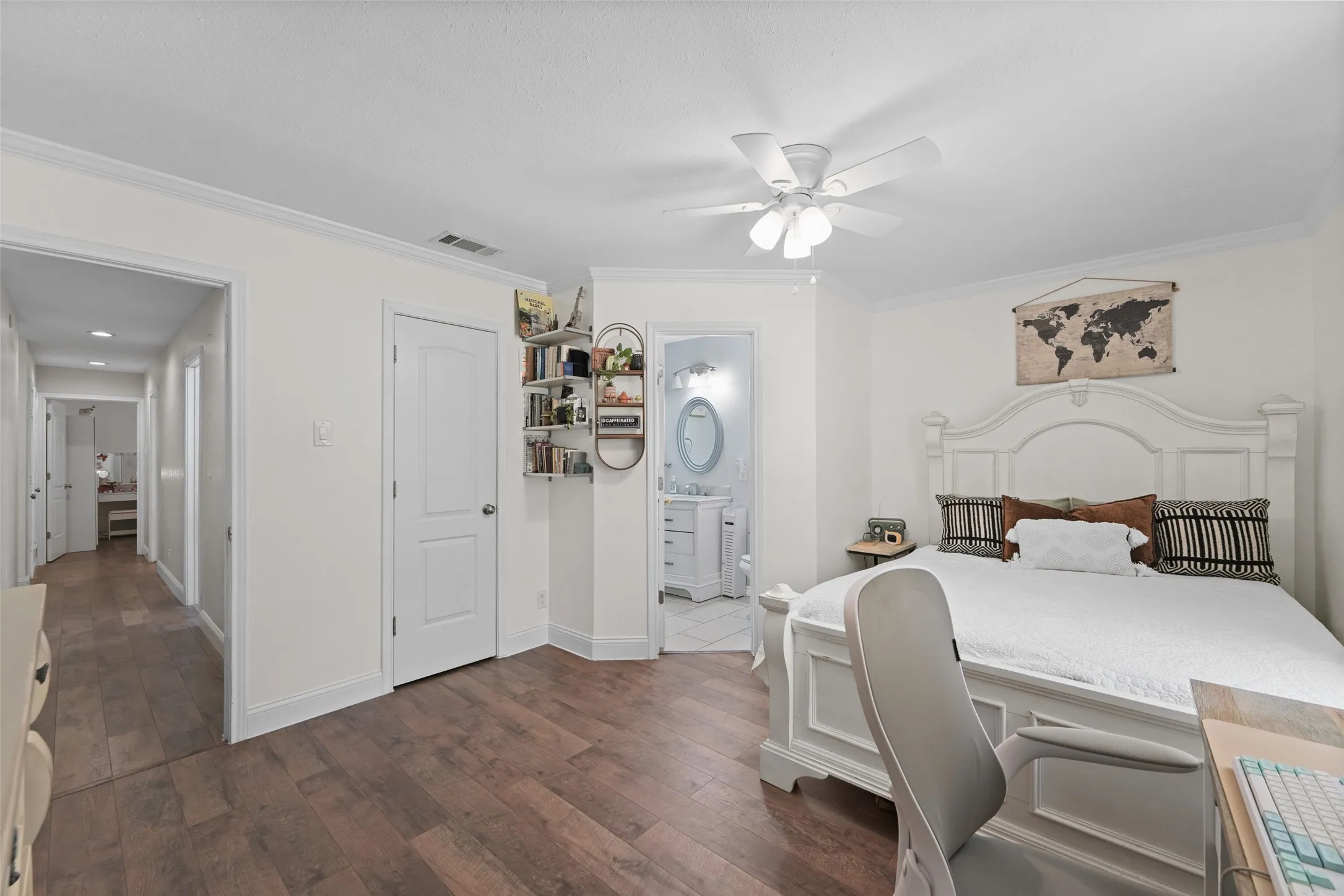 Wood-finish flooring throughout, white interior doors, crown molding, and a ceiling fan with integrated lighting