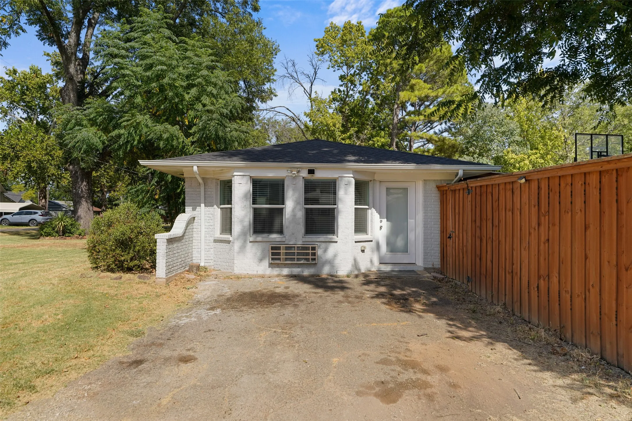 Brick exterior with multiple windows and a private side entrance