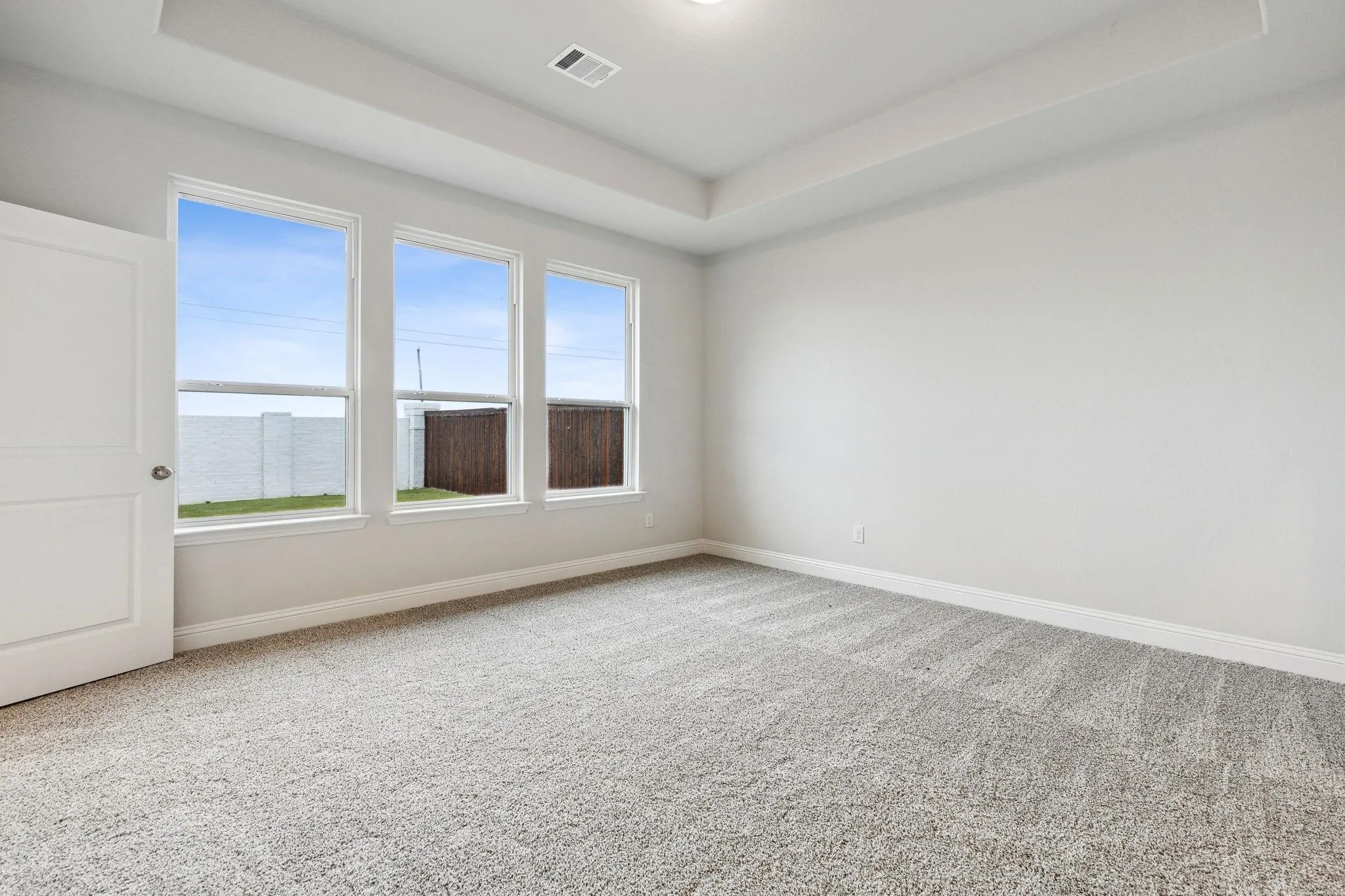 Spare room with a water view, a healthy amount of sunlight, and carpet floors