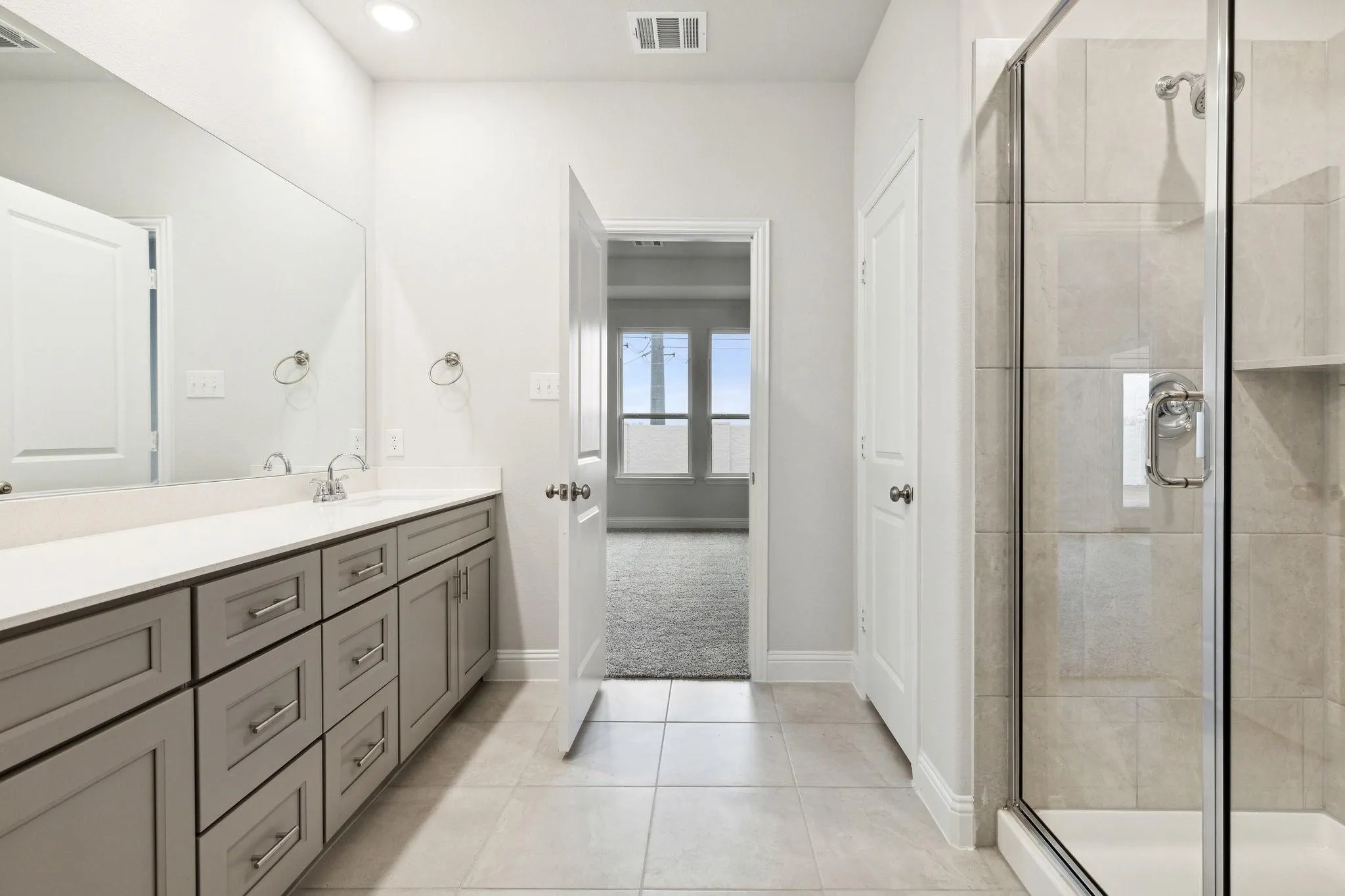 Bathroom with vanity, tile patterned flooring, and an enclosed shower