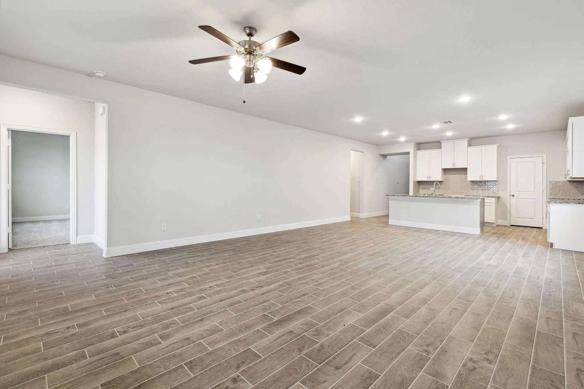 Unfurnished living room with light hardwood / wood-style floors, sink, and ceiling fan
