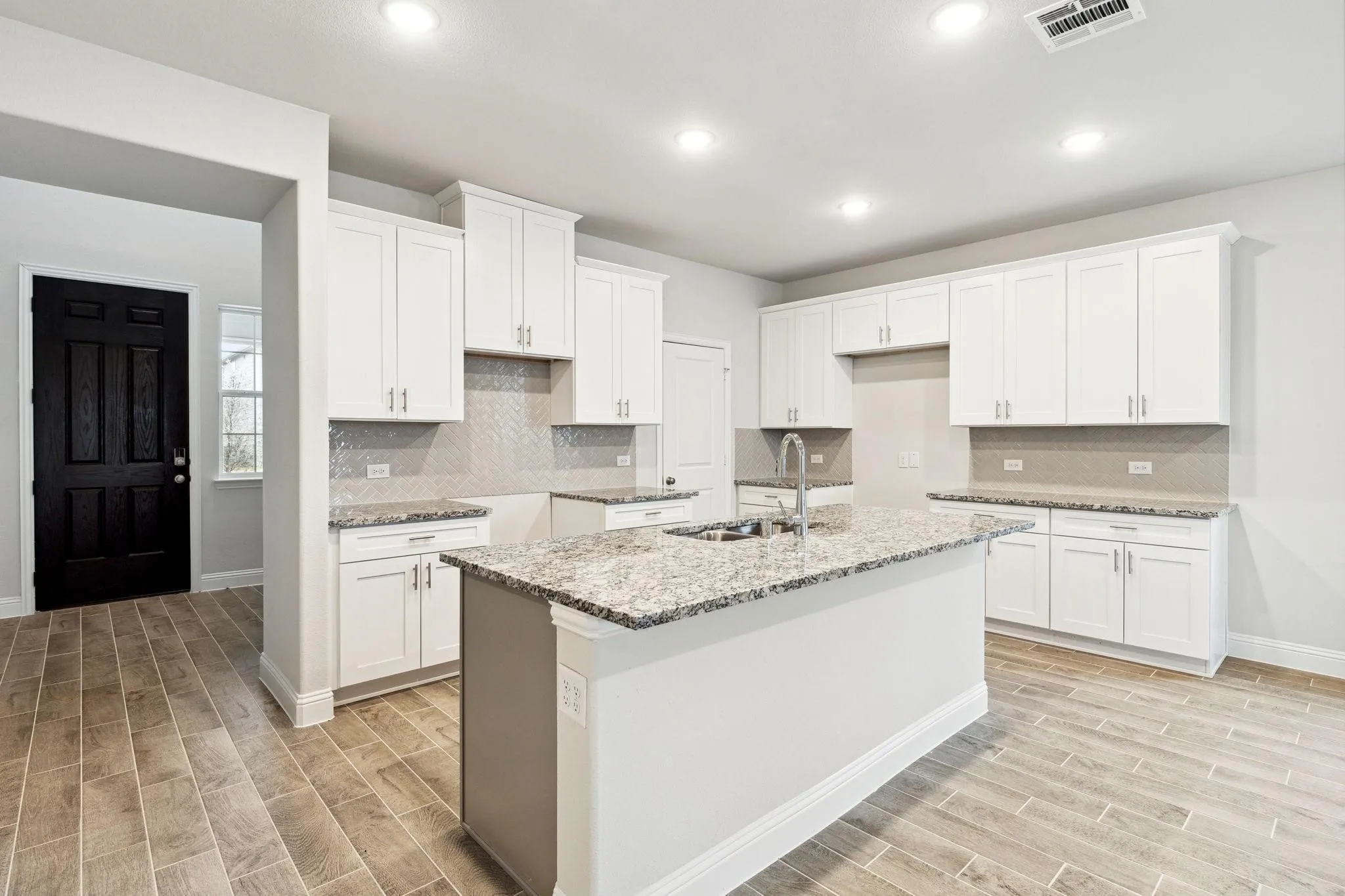 Kitchen featuring light stone countertops, sink, white cabinets, and light hardwood / wood-style floors