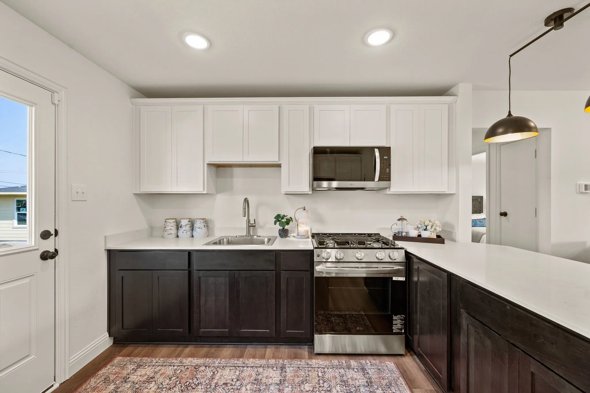 Sleek stainless steel and black appliances include Gas Range and Microwave; Under sink is pre-wired for a disposal